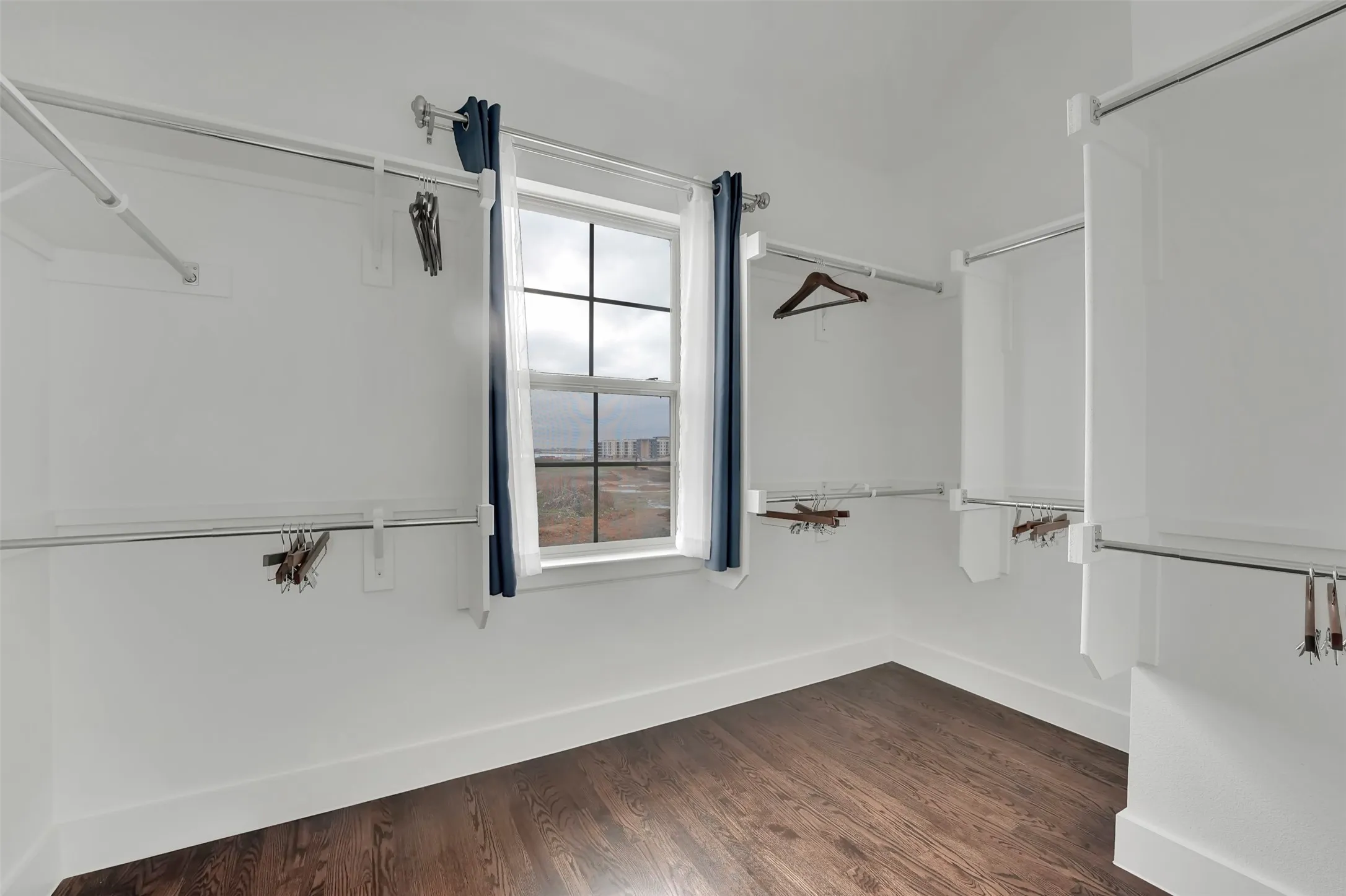 Walk in closet featuring dark wood finished floors