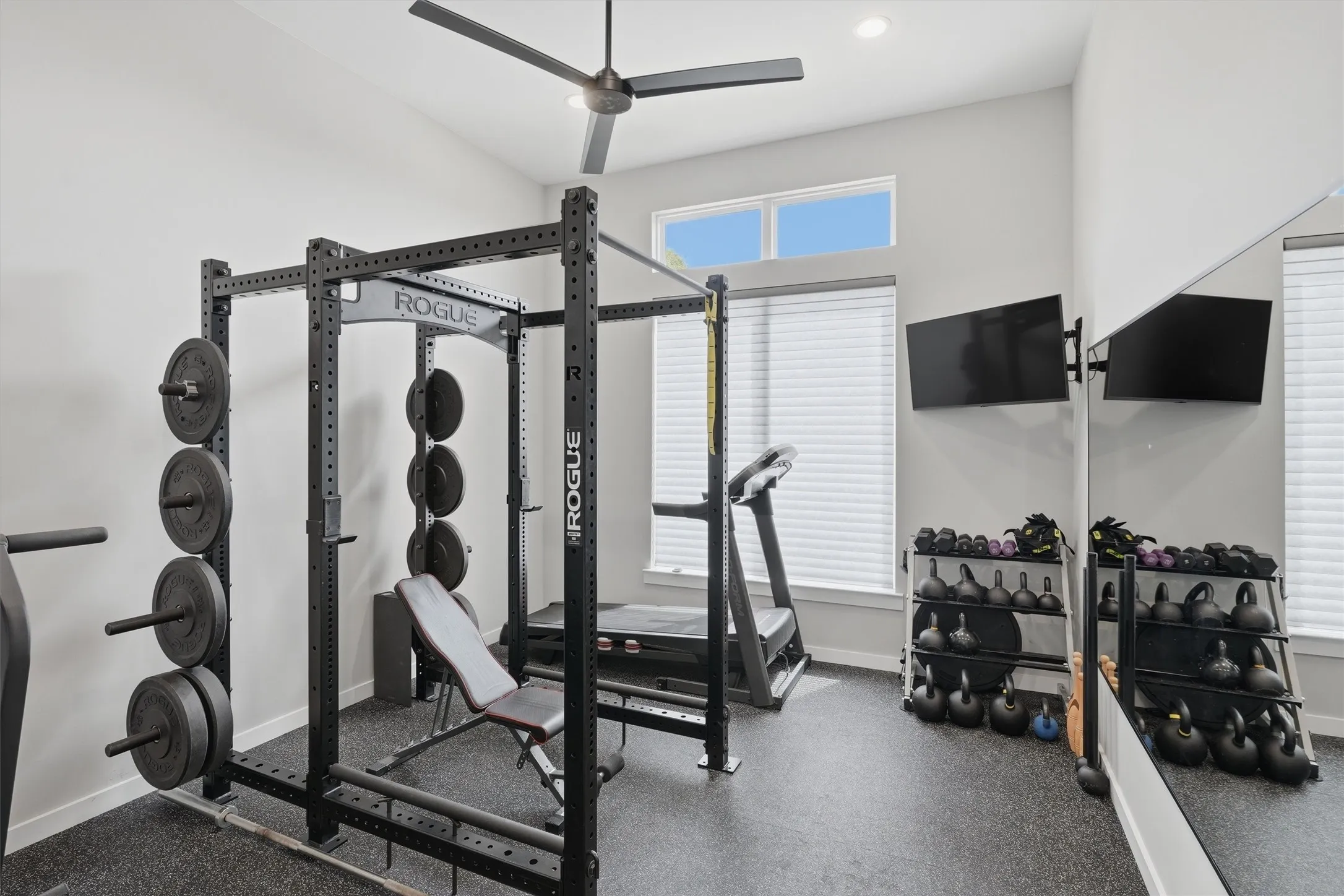 Exercise area featuring dark rubber floors and a ceiling fan