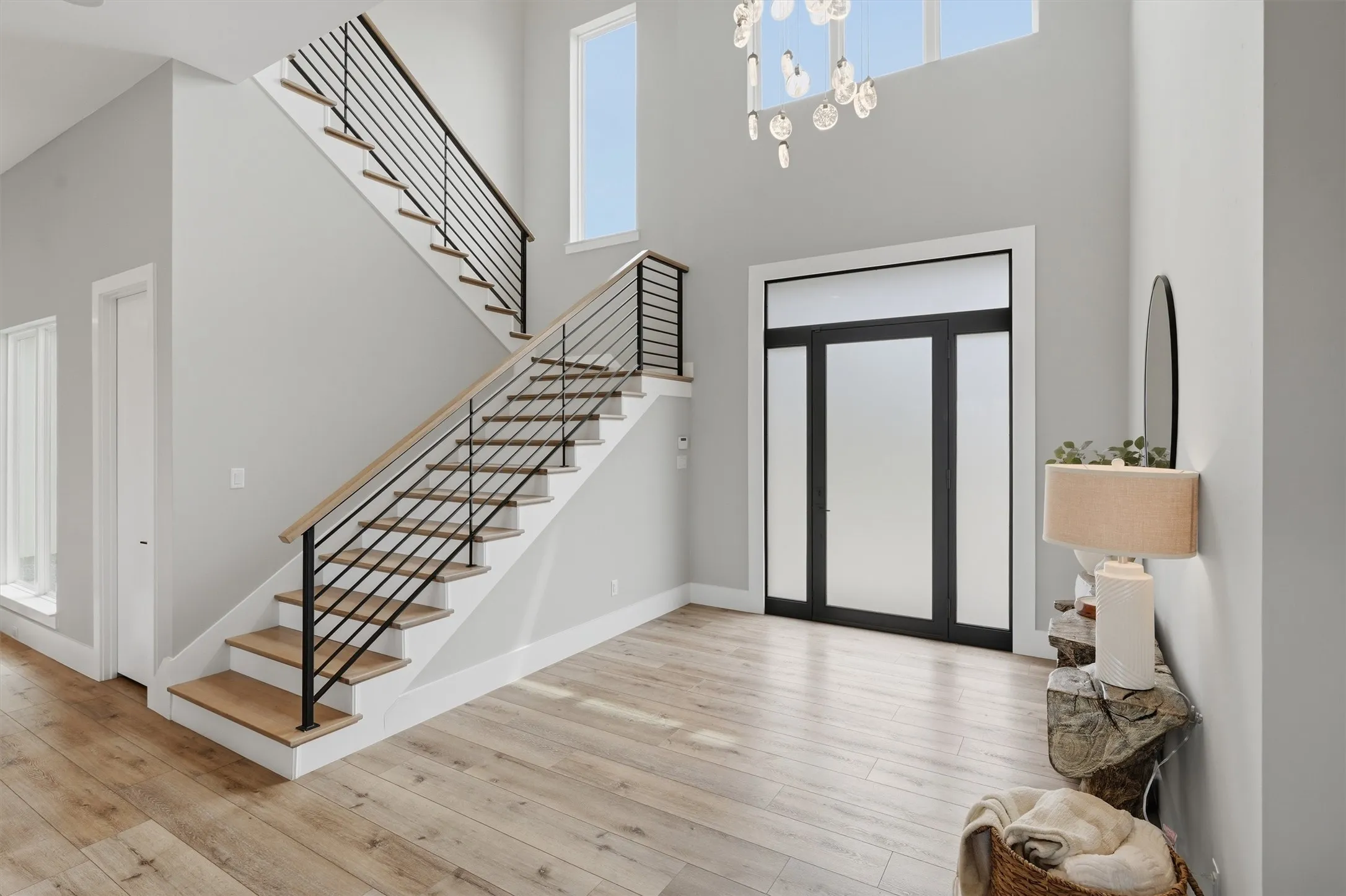 Entrance foyer featuring light wood finished floors and a high ceiling and contemporary lighting
