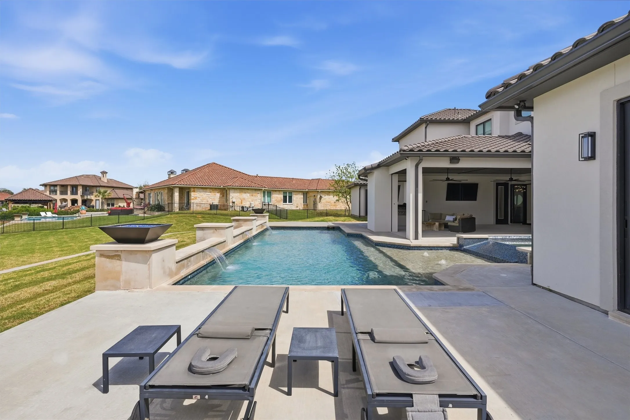 Integrated pool / spa with a patio area, a fenced backyard, an outdoor lounge area, and a residential view