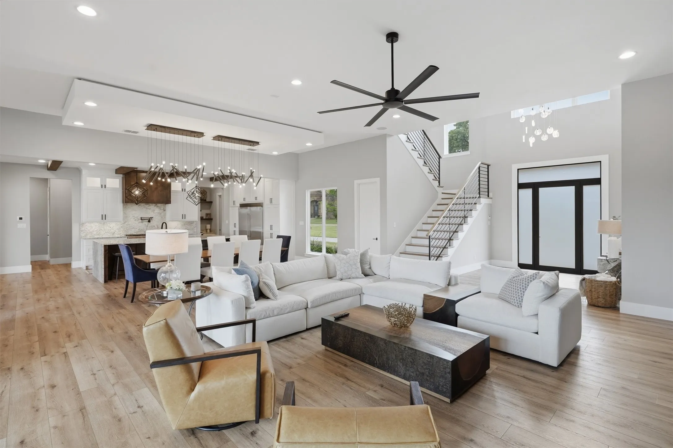 Living room featuring a chandelier, light wood-style flooring, and a ceiling fan