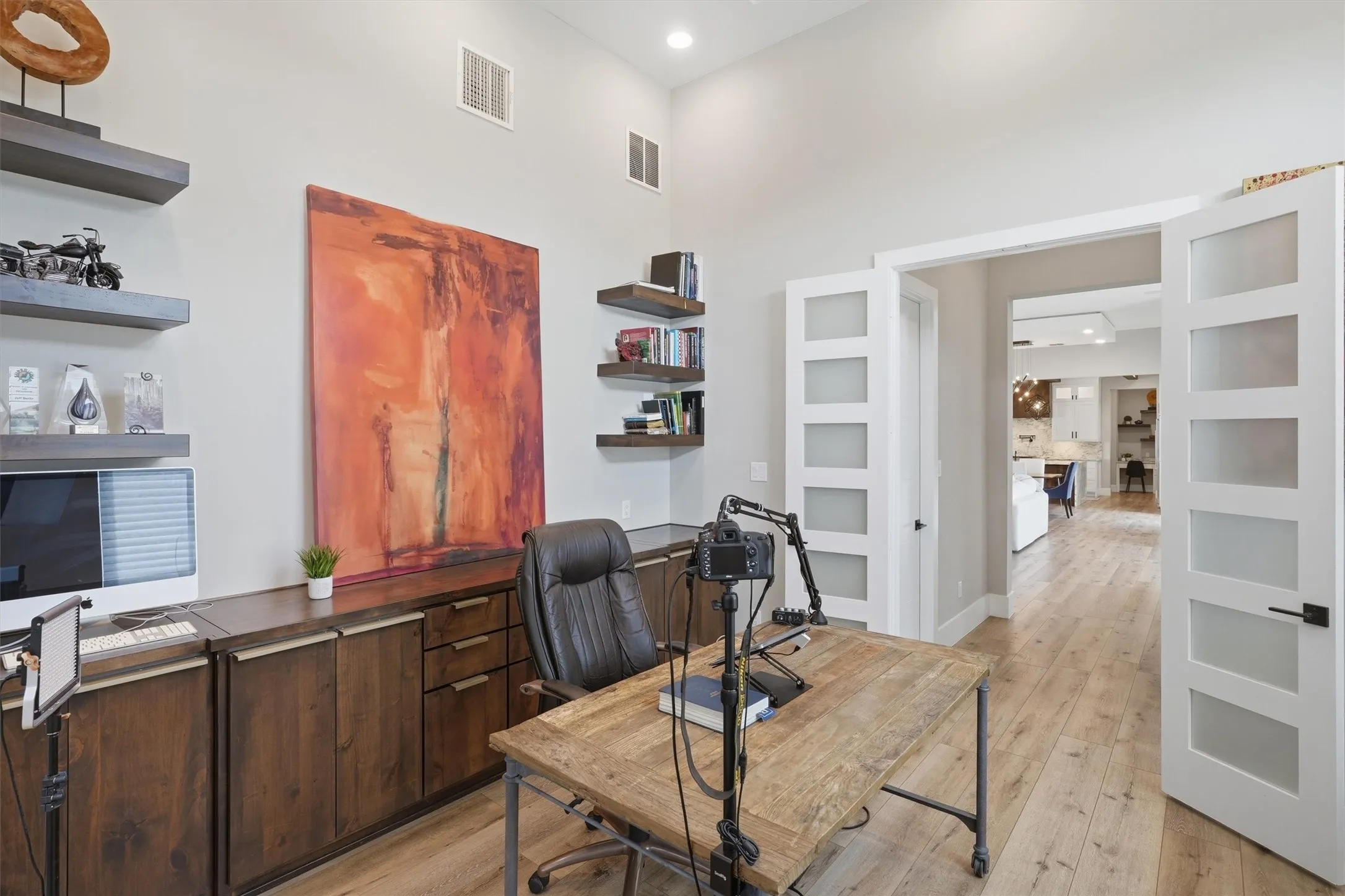 Office space featuring light wood finished floors, recessed lighting, and a high ceiling