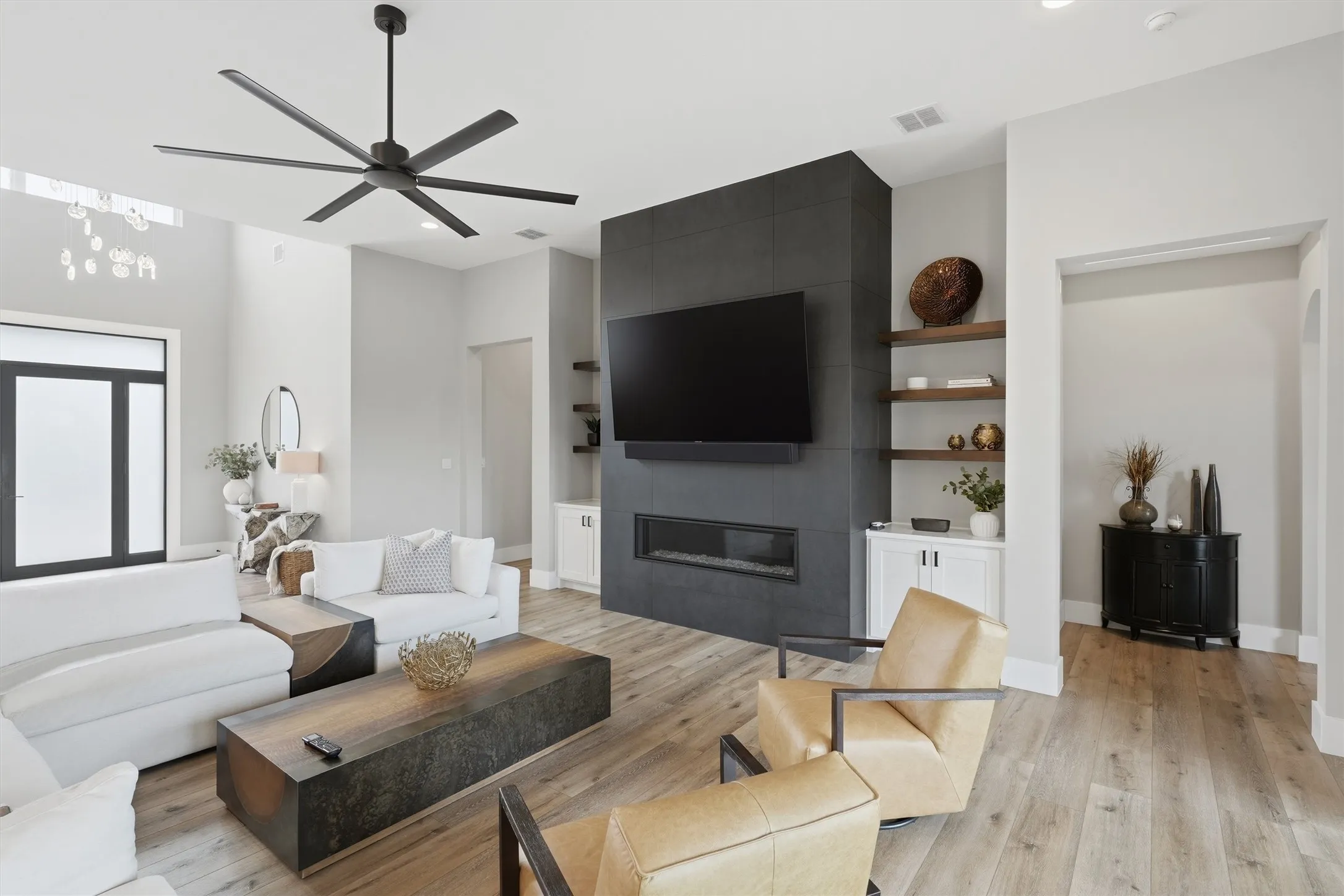 Living room featuring a ceiling fan, light wood-style flooring, built in shelves, and recessed lighting