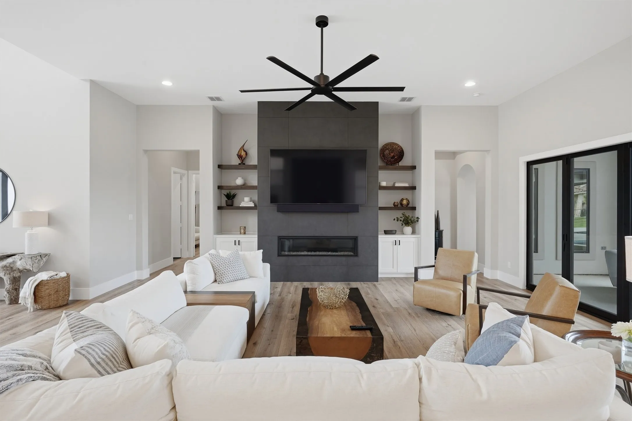Living area featuring light wood-style floors, ceiling fan, a tile fireplace, built in features, and recessed lighting