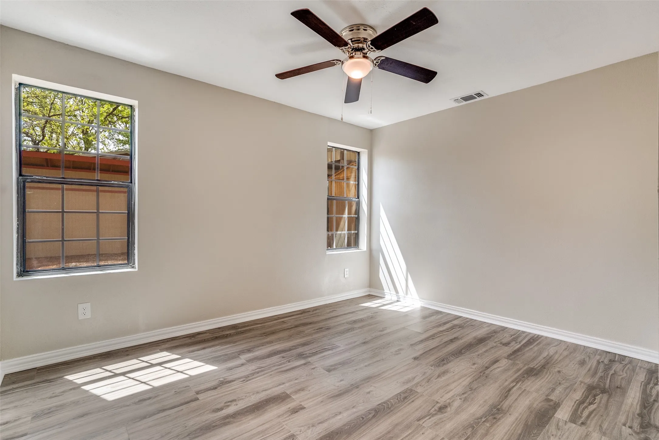 Empty room with light wood-style flooring and a ceiling fan