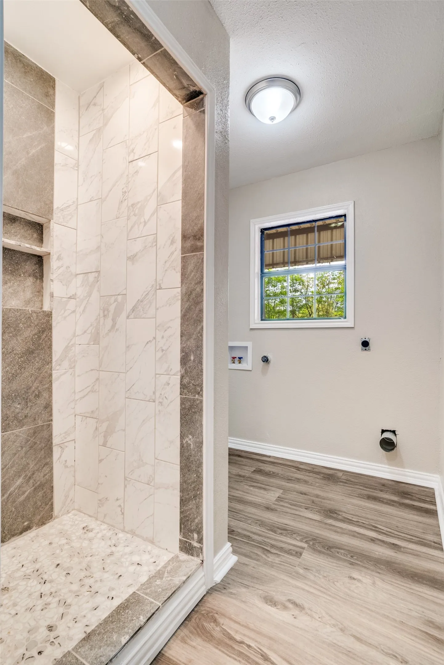 Bathroom with a shower stall and light wood finished floors