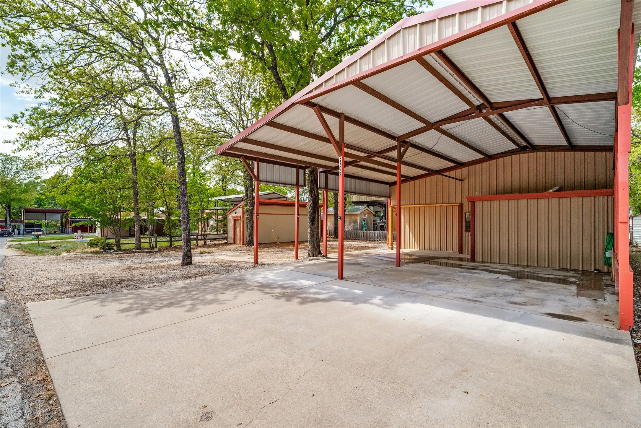 View of parking featuring a detached carport and concrete driveway
