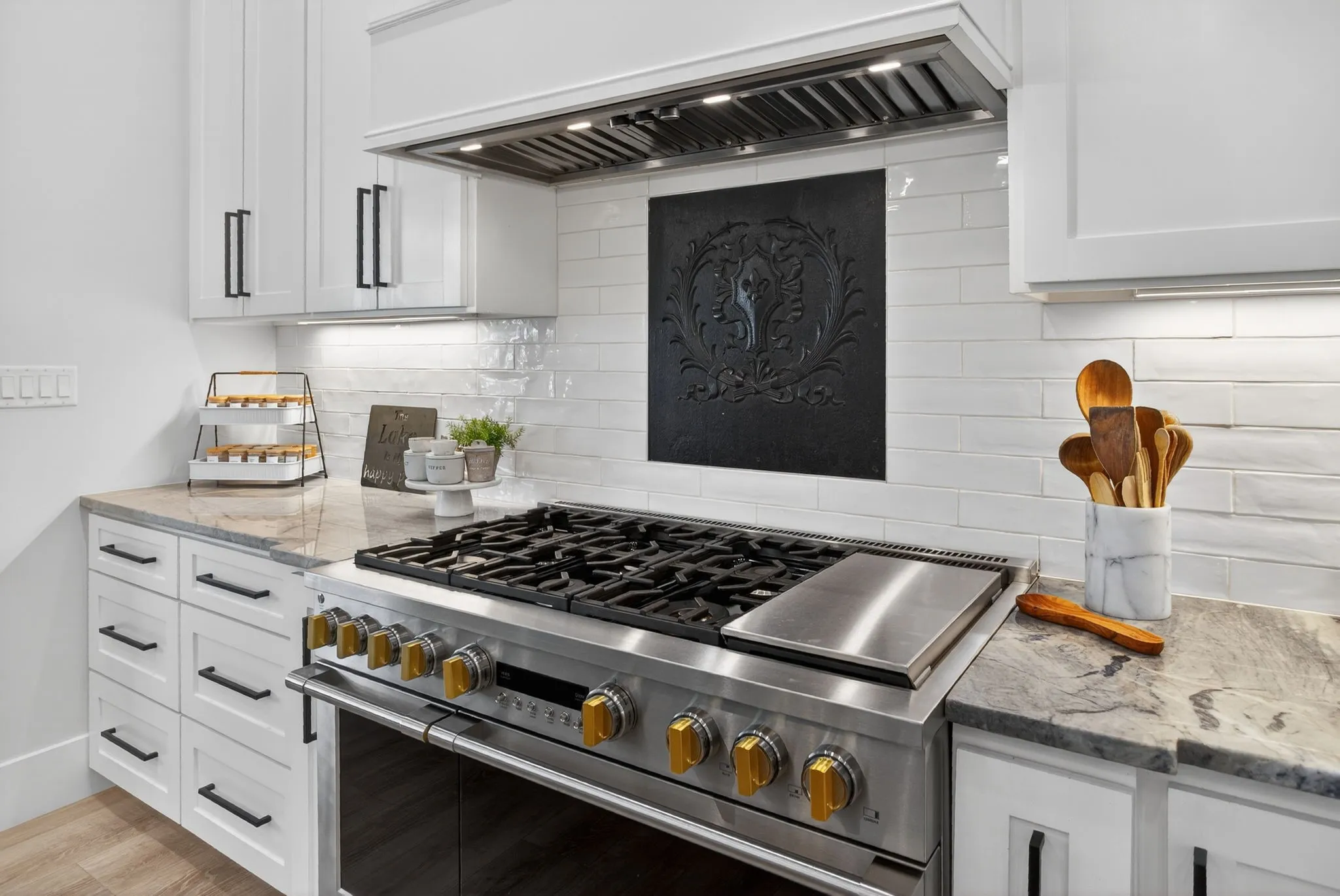 The inset above the stove is an antique, European fireback. This detail provides the perfect touch in this gourmet kitchen. Functional yet, designer touches throughout.