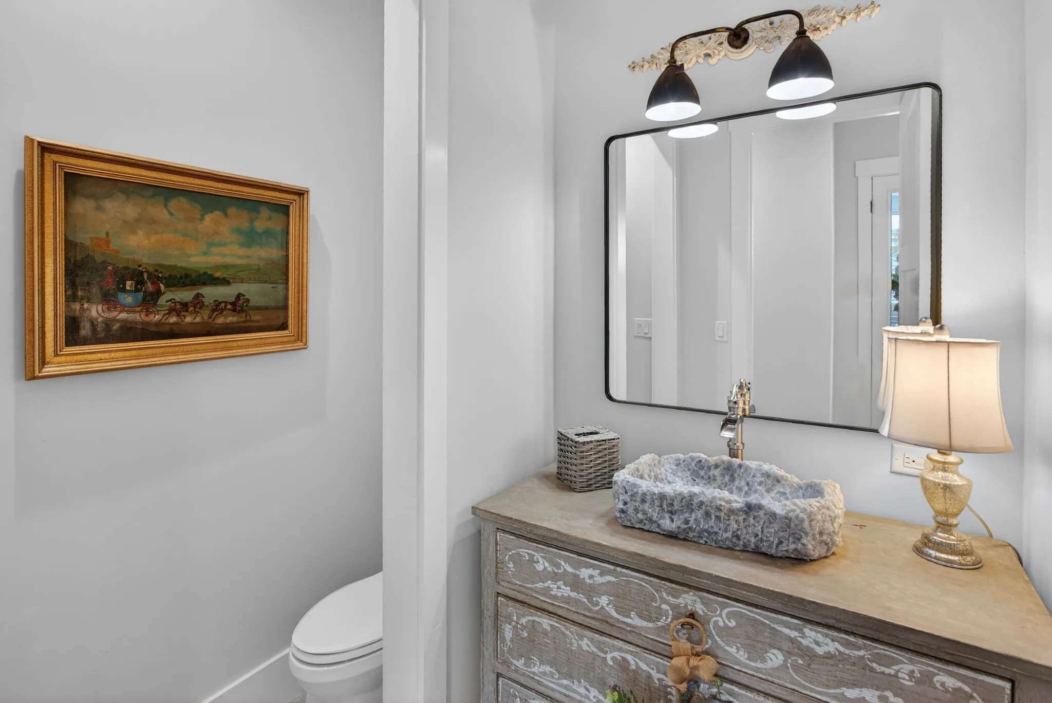 This half-bath is fabulous! The vintage French antique chest is complete with the hand-carved stone sink vessel. This is a one-of-a-kind feature.