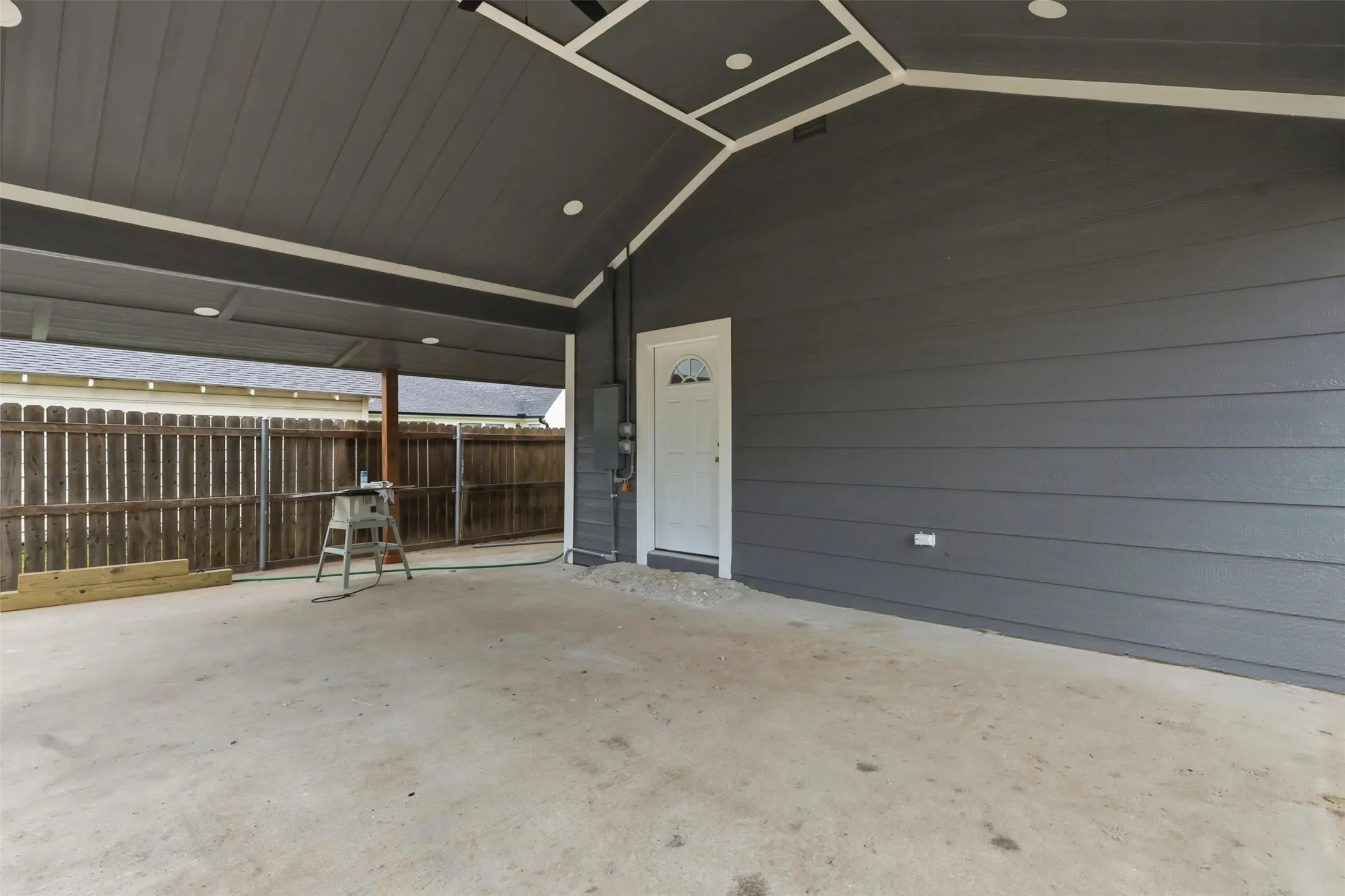 Covered patio featuring a concrete slab, recessed lighting, and a white exterior door
