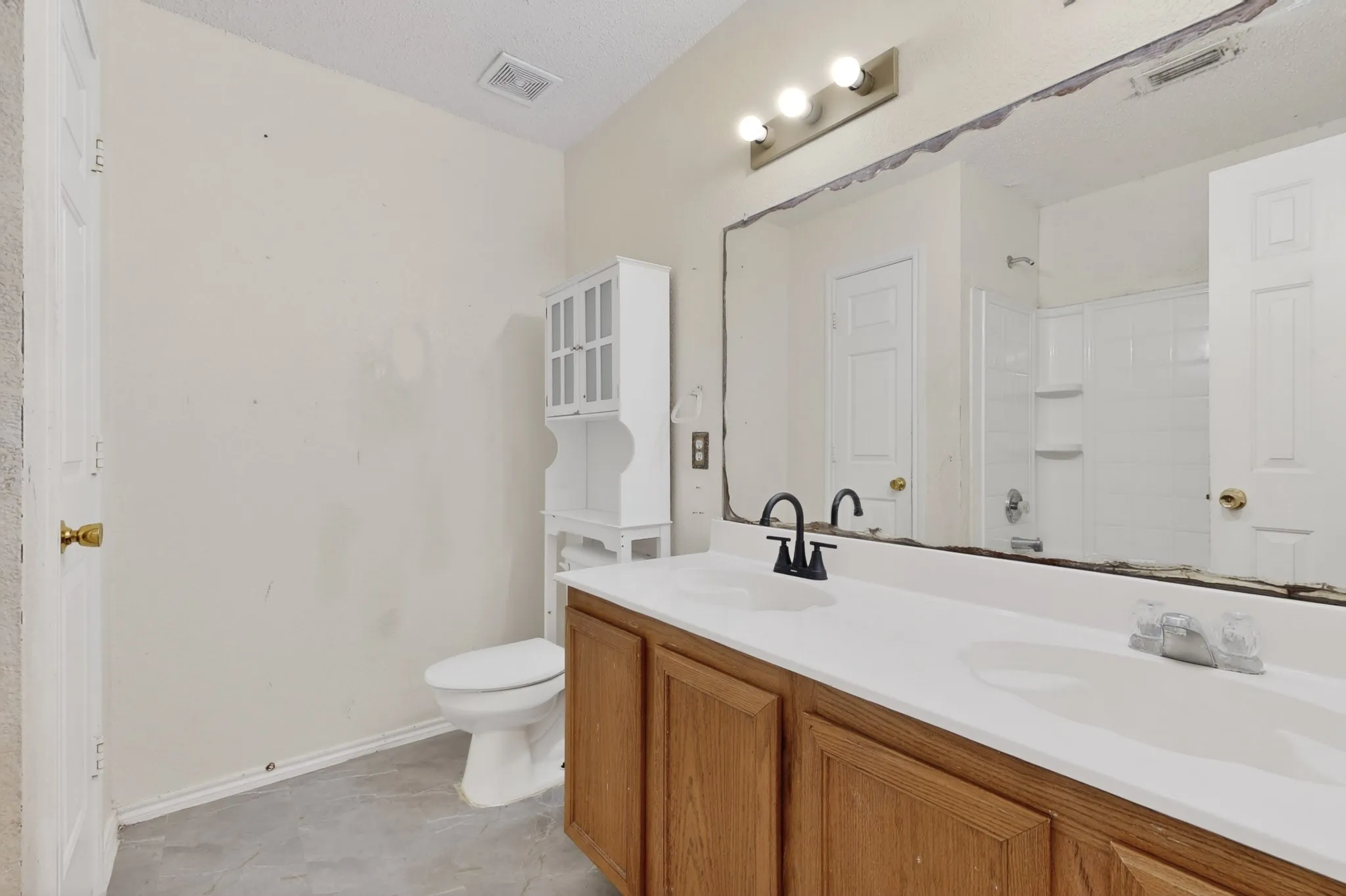 Full bathroom with double vanity and a shower