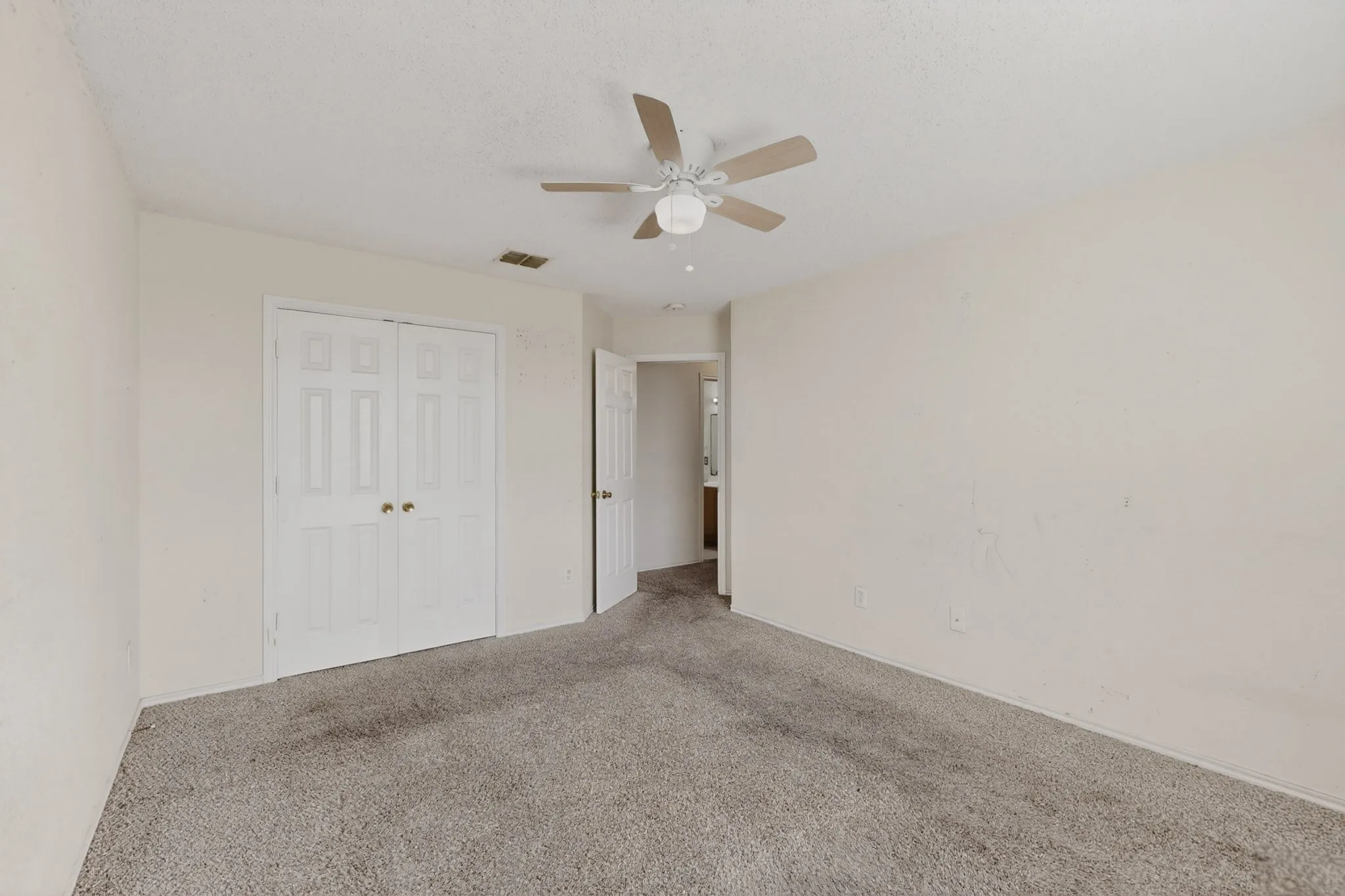 Unfurnished bedroom with carpet flooring, a closet, and a ceiling fan