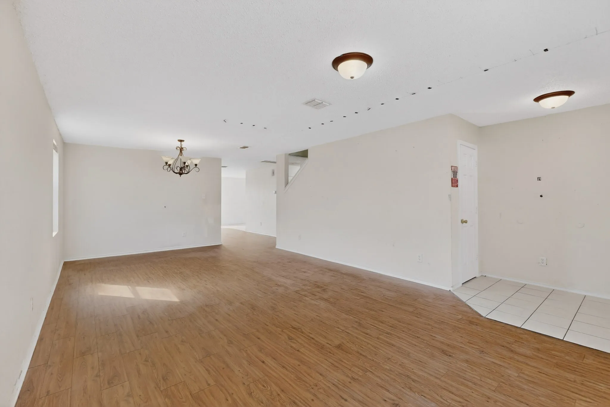 Unfurnished room with light wood-type flooring and hanging lights