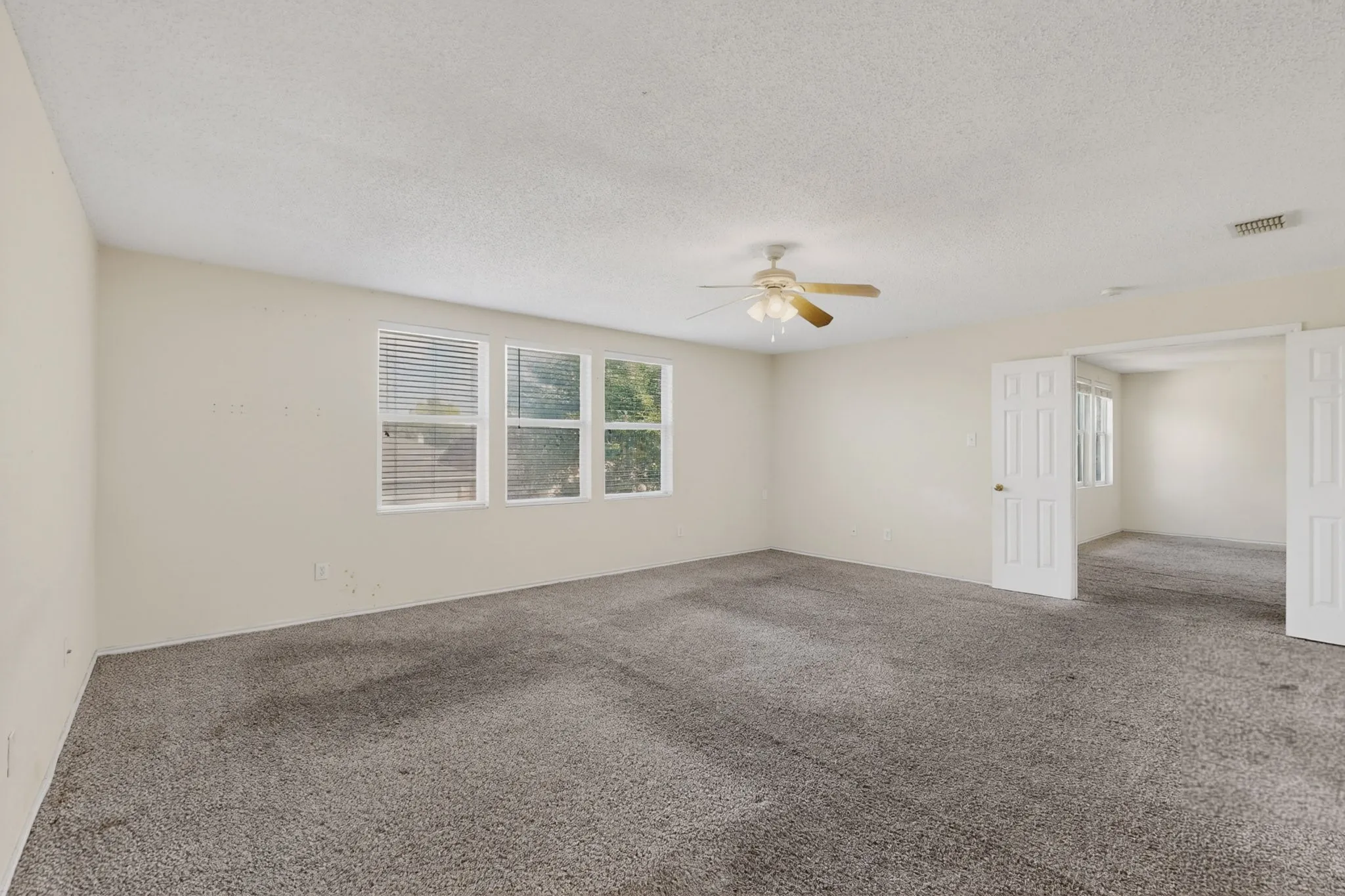 Unfurnished room with carpet floors, a ceiling fan, and a textured ceiling