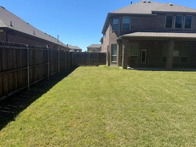 Expansive rear yard featuring a large grass area and privacy fencing