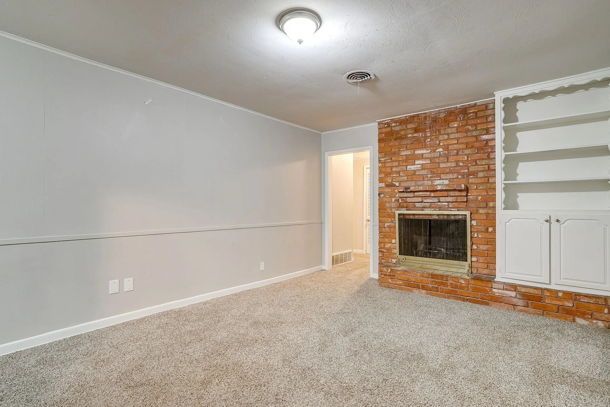 Brick fireplace featuring an integrated firebox and hearth