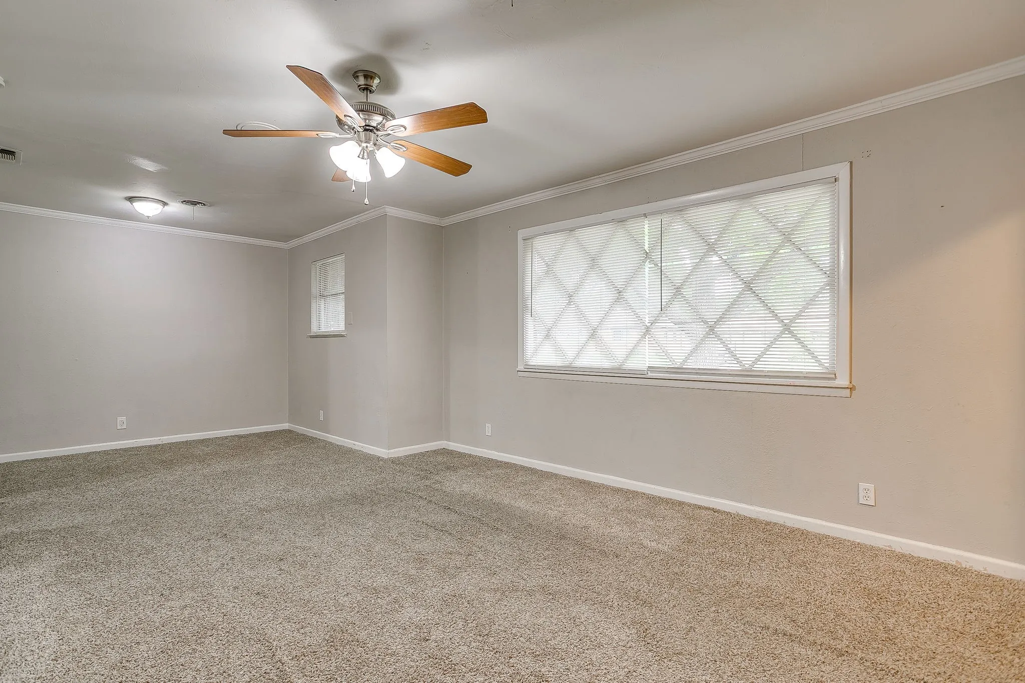 Spacious room featuring textured carpeting and light-toned walls