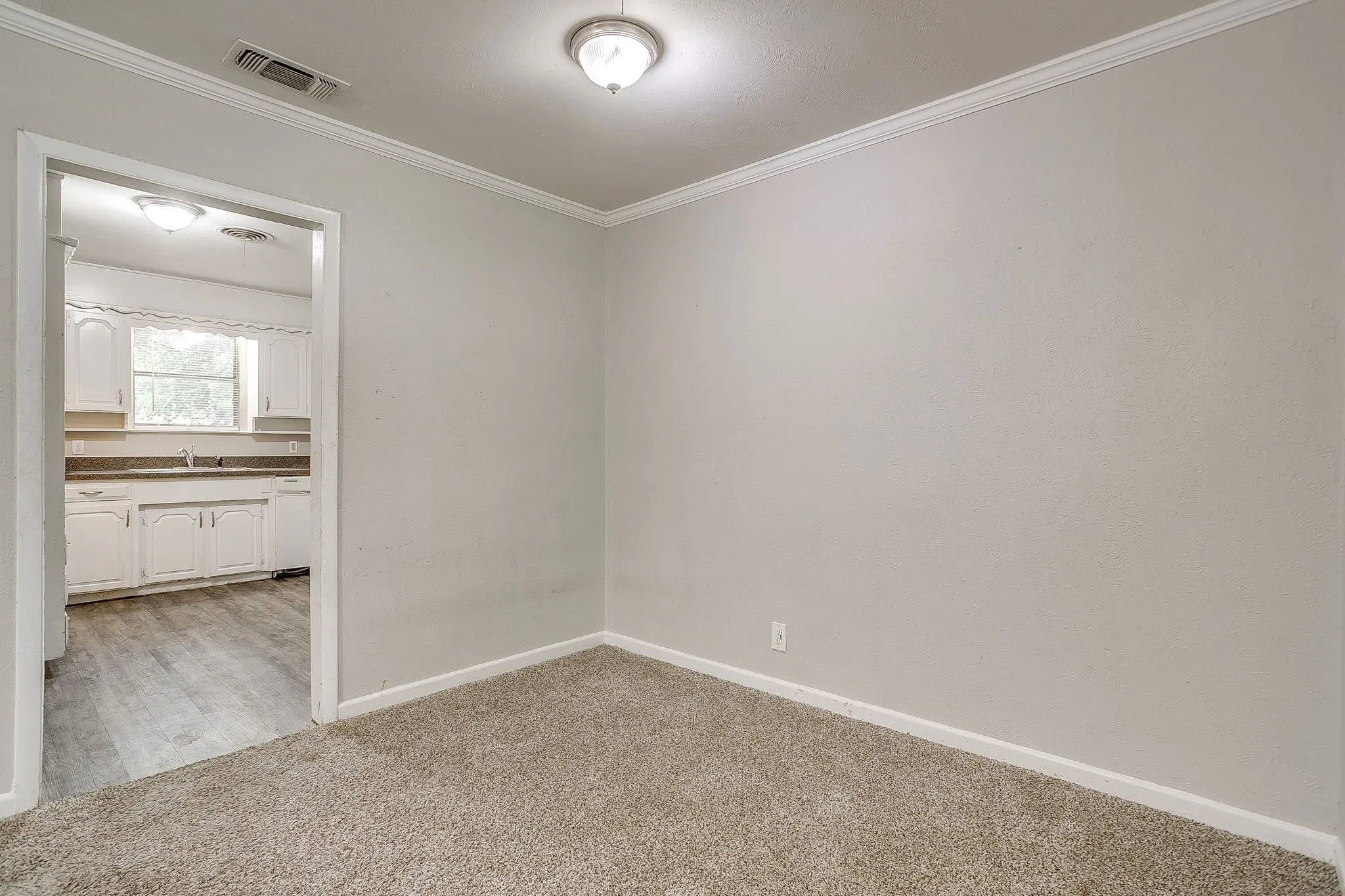 Neutral wall tones with crown molding, recessed lighting, and soft carpeting