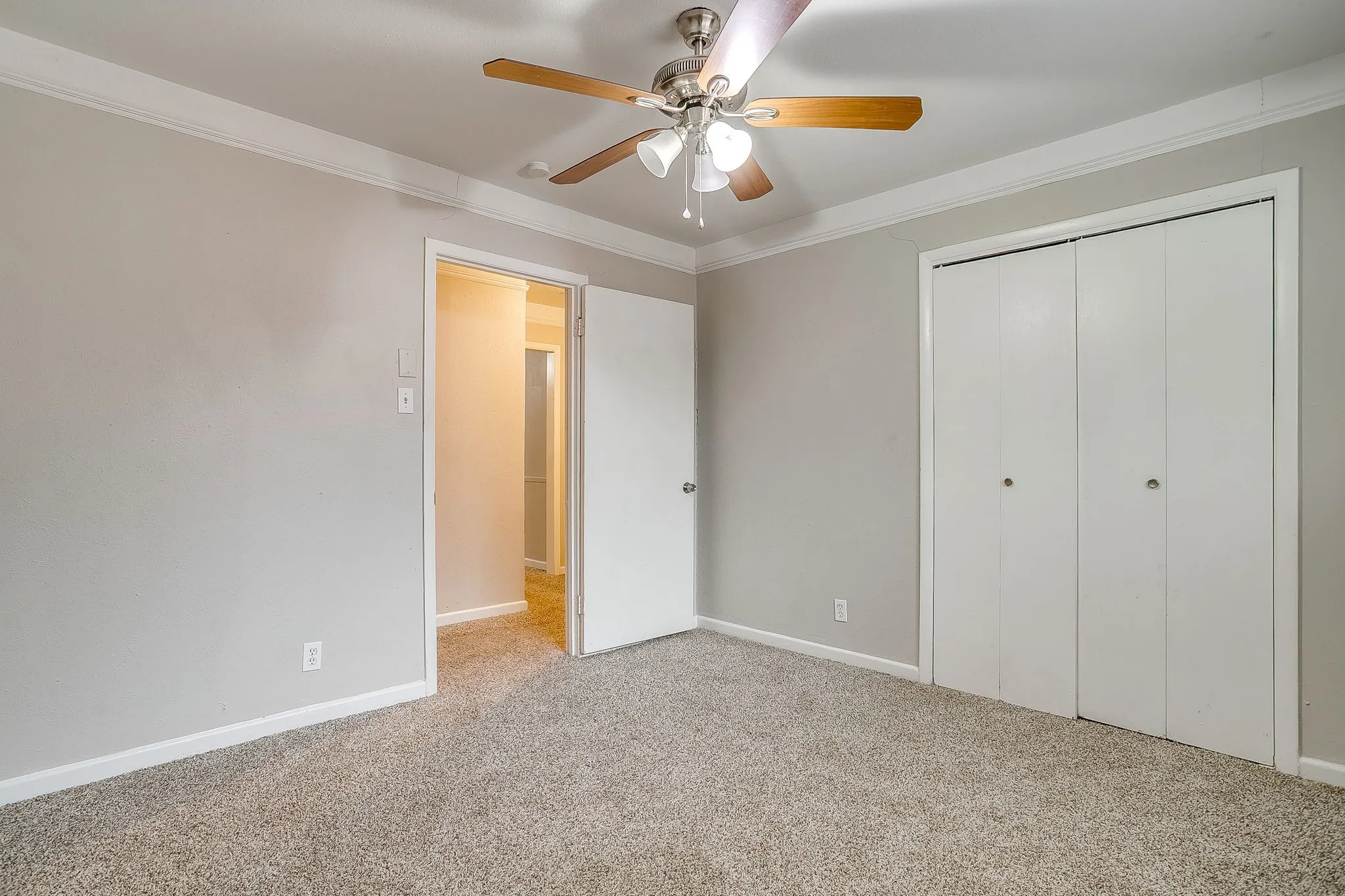Carpeted room with neutral wall tones and crown molding