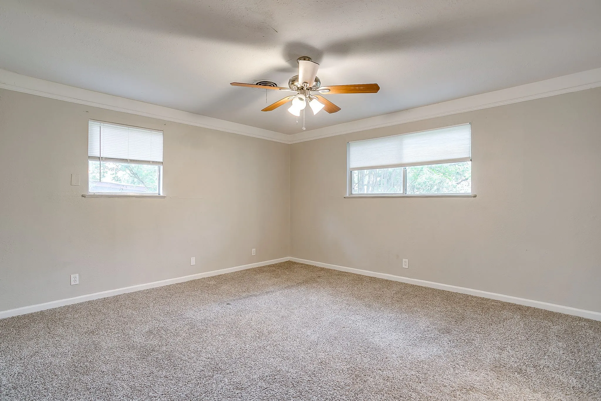 Spacious room with neutral wall tones and textured carpeting