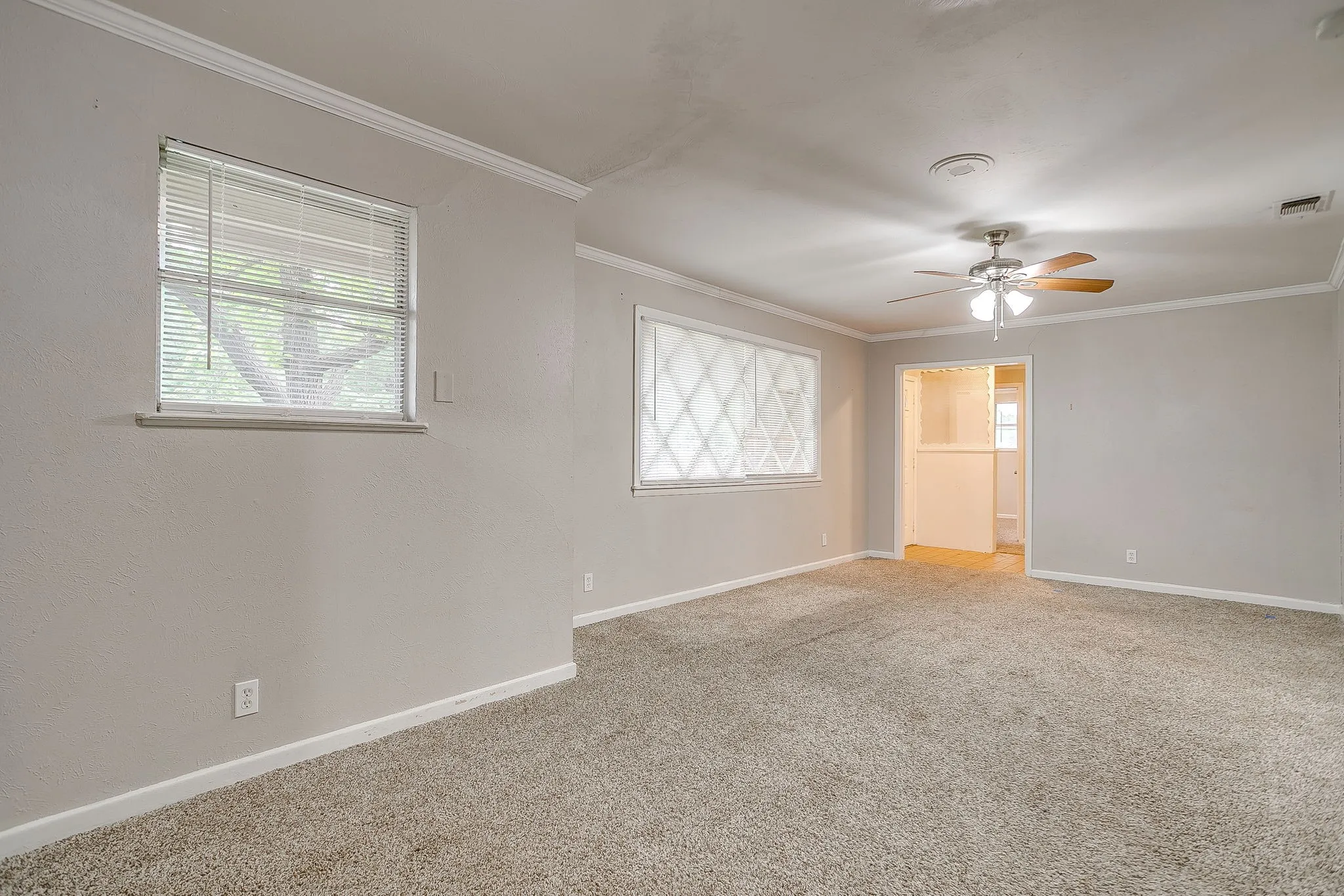 Spacious room featuring carpet flooring and light-toned wall paint