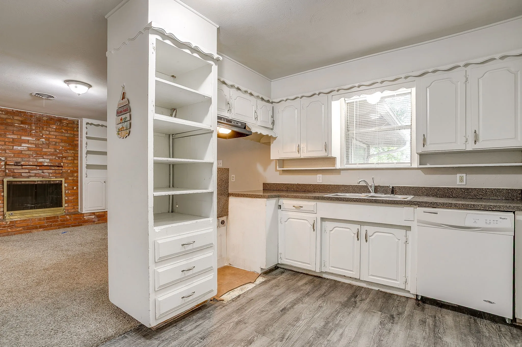 Kitchen featuring white cabinetry, a double basin sink, and a white dishwasher