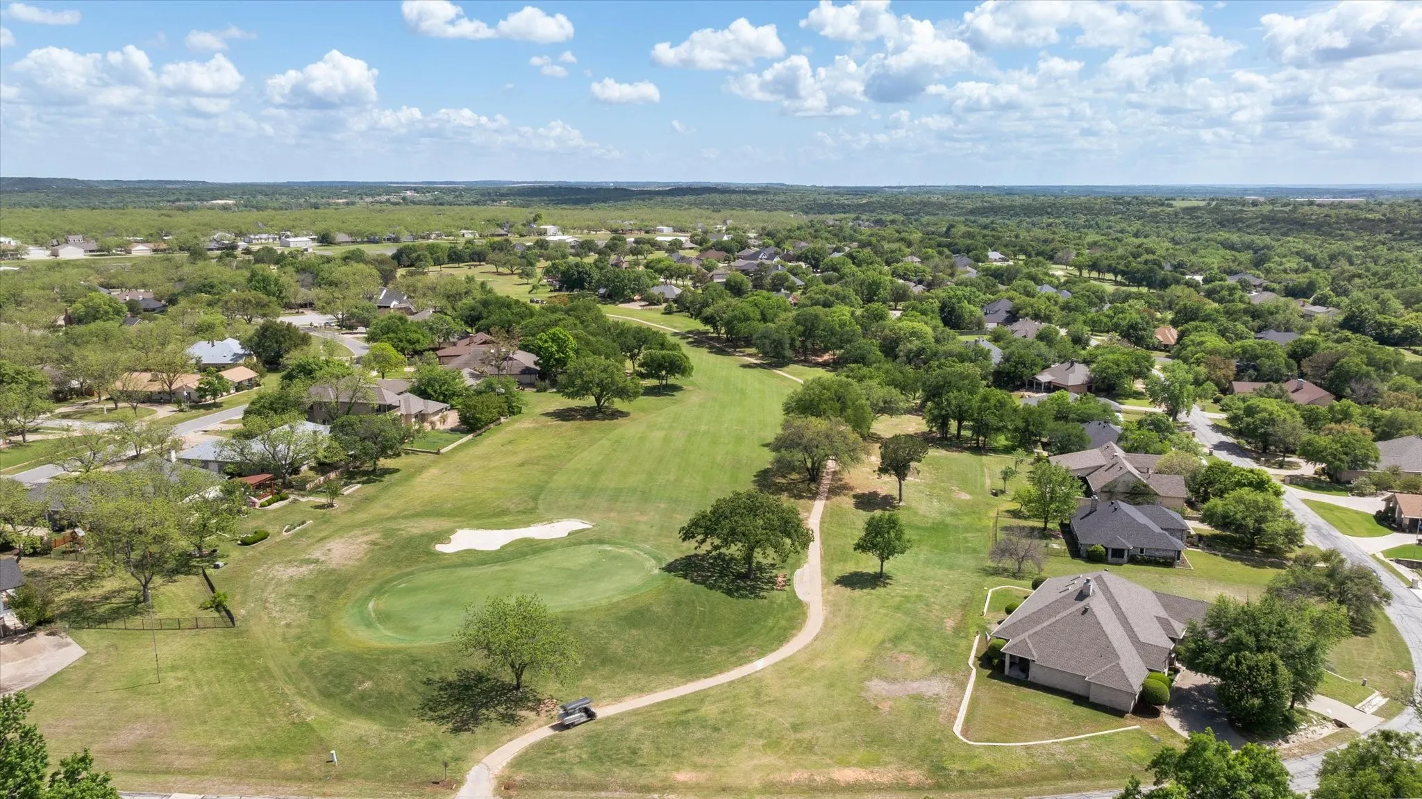 Aerial view of residential area featuring a golf course