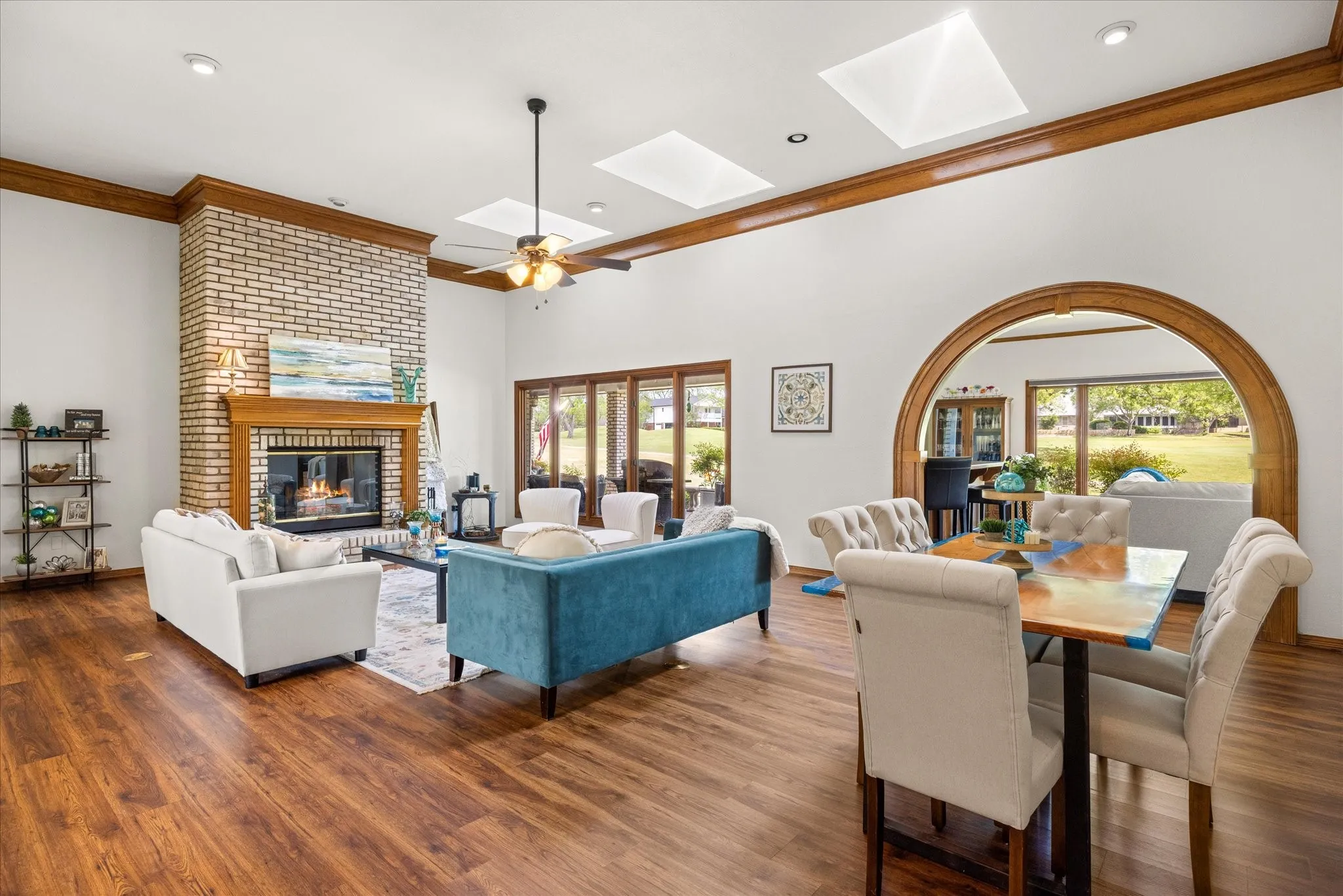 Living room featuring a skylight, crown molding, wood finished floors, plenty of natural light, and recessed lighting