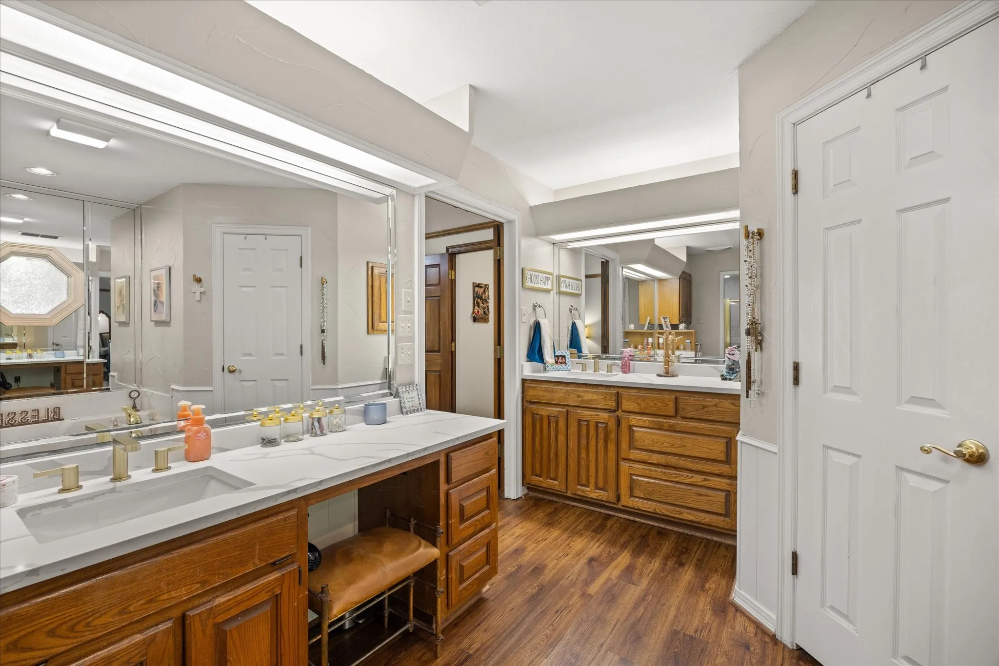 Bathroom featuring two vanities and dark wood finished floors