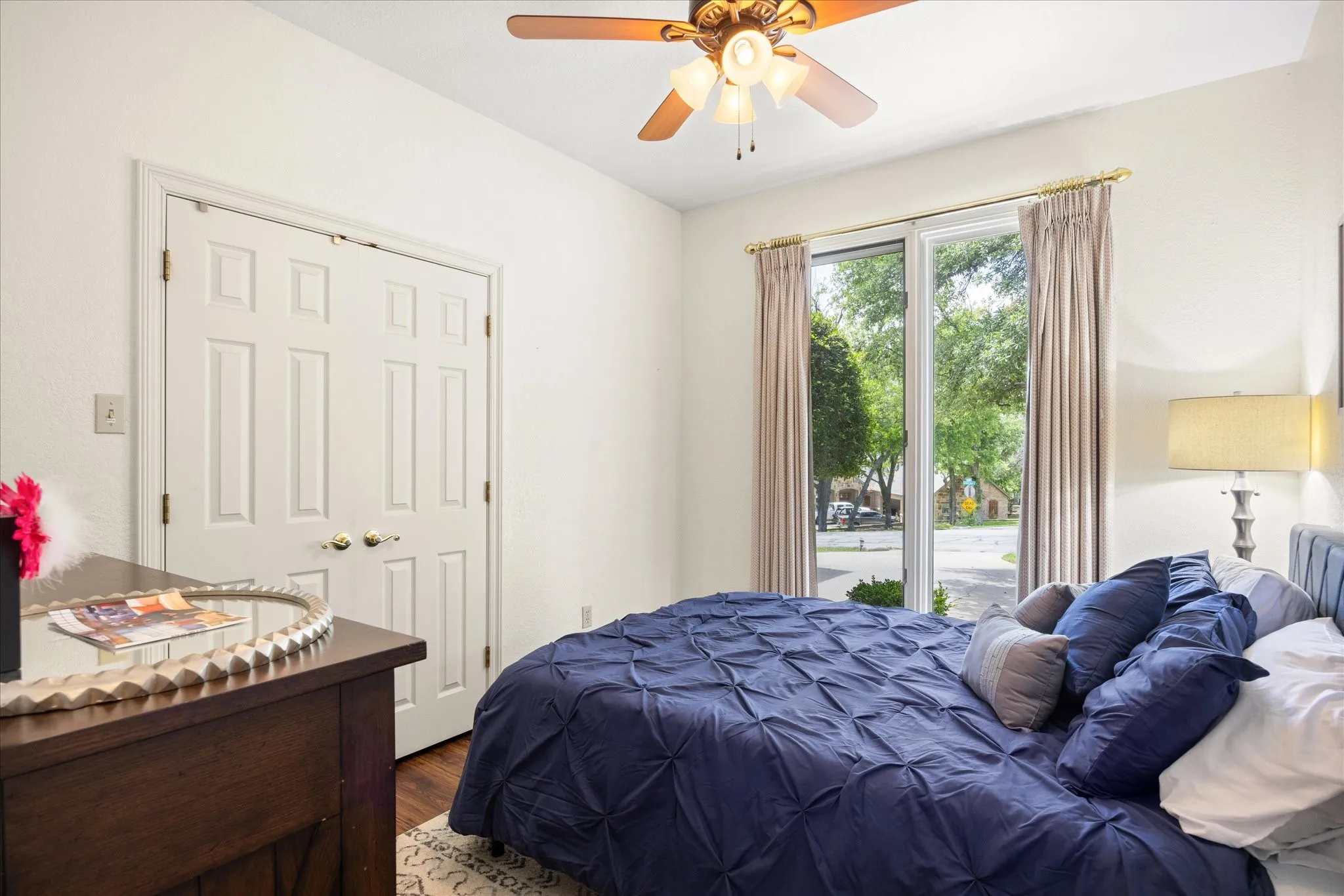 Bedroom with access to exterior, wood finished floors, and ceiling fan
