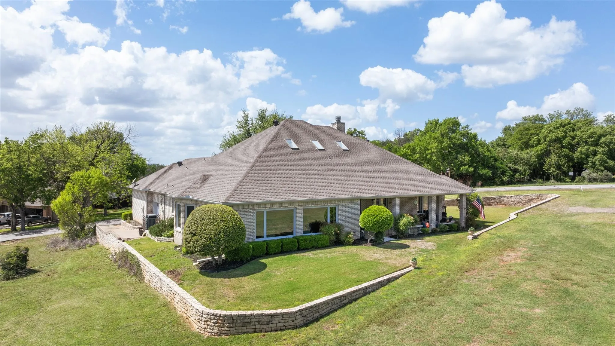 View of front of house featuring a front lawn, a shingled roof, and brick siding