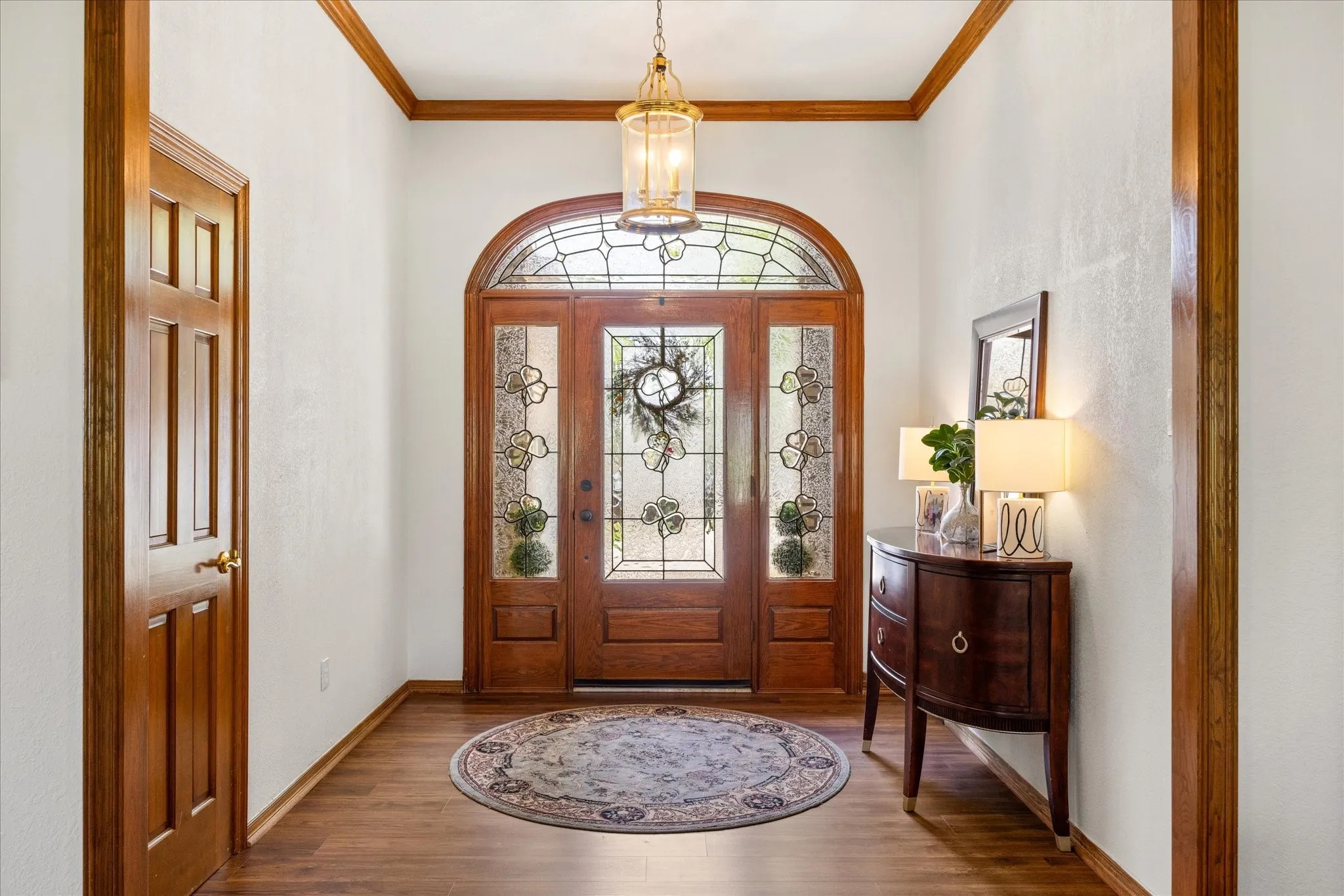 Foyer entrance featuring crown molding and wood finished floors