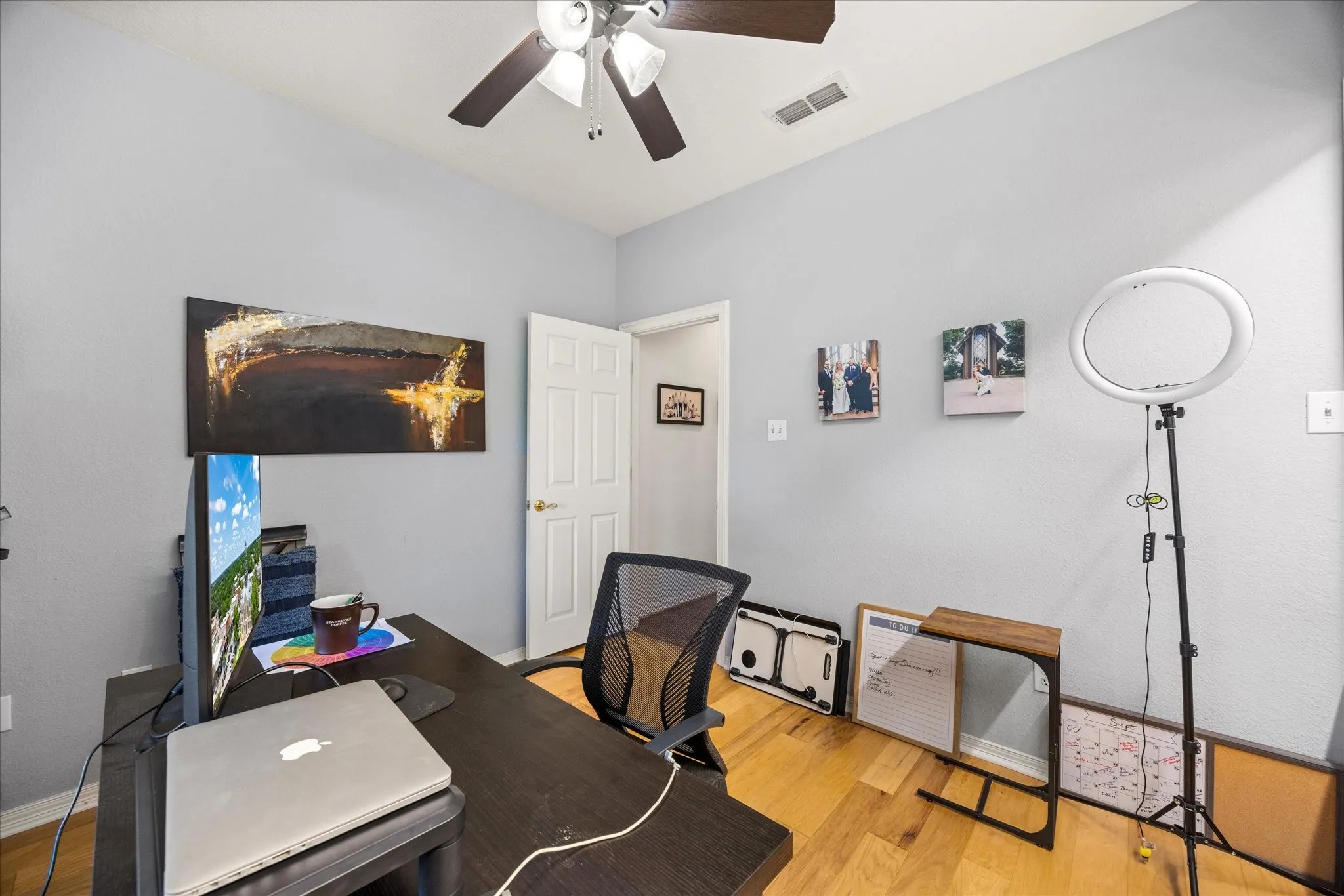 Home office with light wood finished floors and ceiling fan