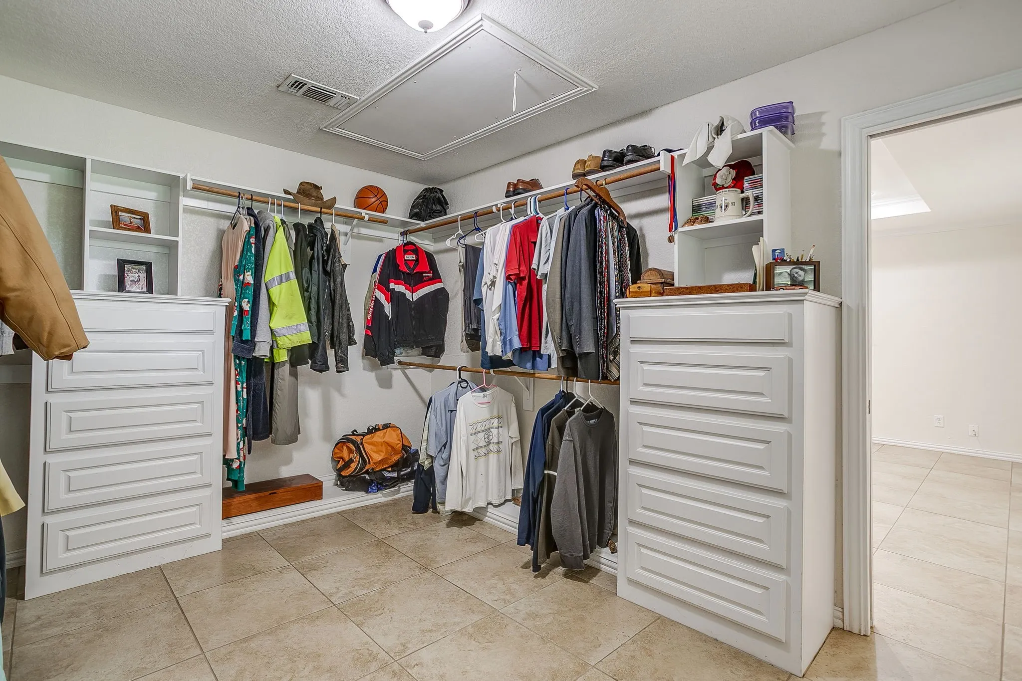 Huge Walk in Primary Closet with custom closet system and built ins