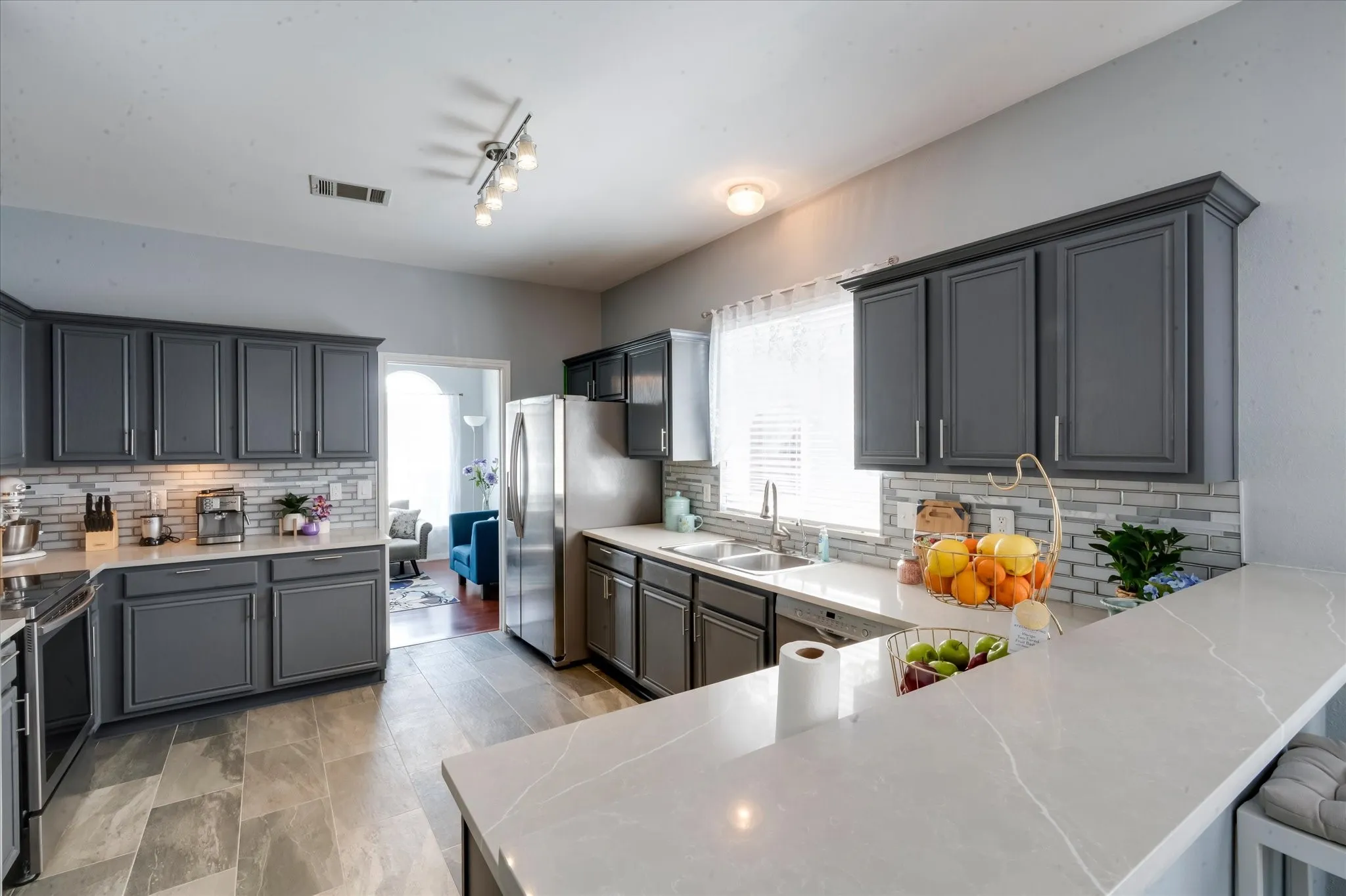 Beautiful spacious kitchen with upgraded countertops,backspash, upgraded flooring, large breakfast bar, stainless steel appliances