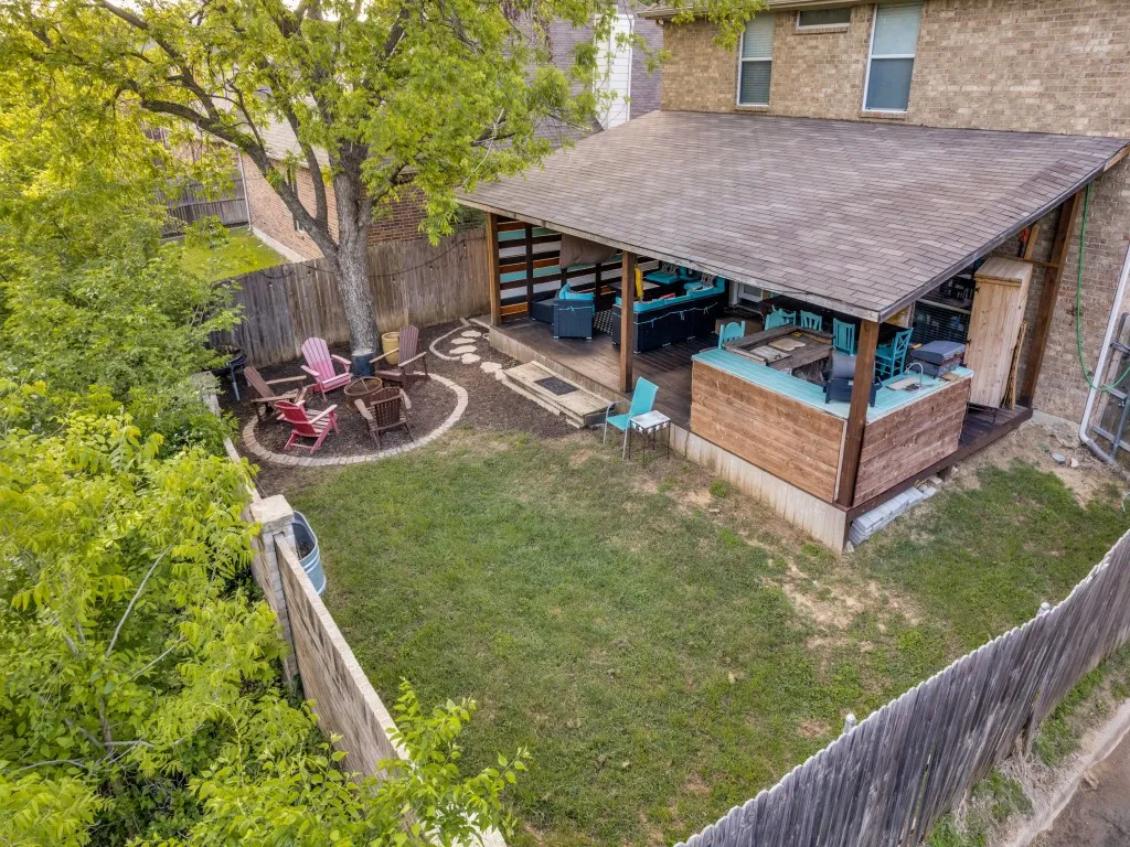 Fenced backyard featuring an outdoor fire pit, a deck, and a patio area