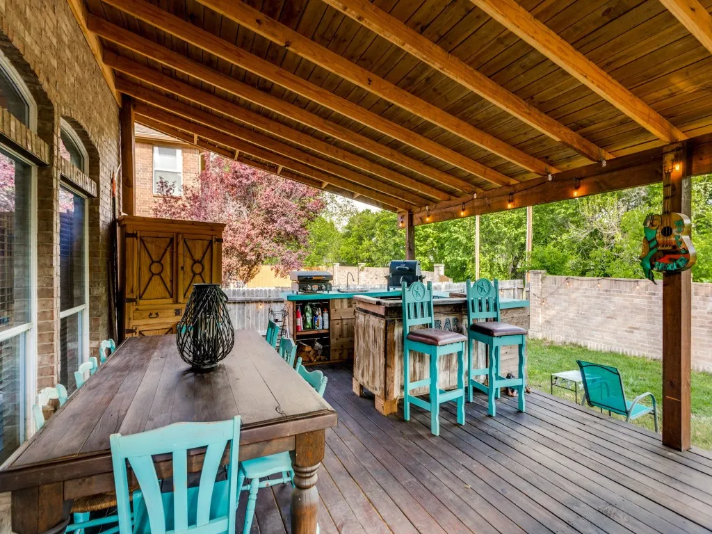 Wooden deck with an outdoor bar and dining area and area for grilling