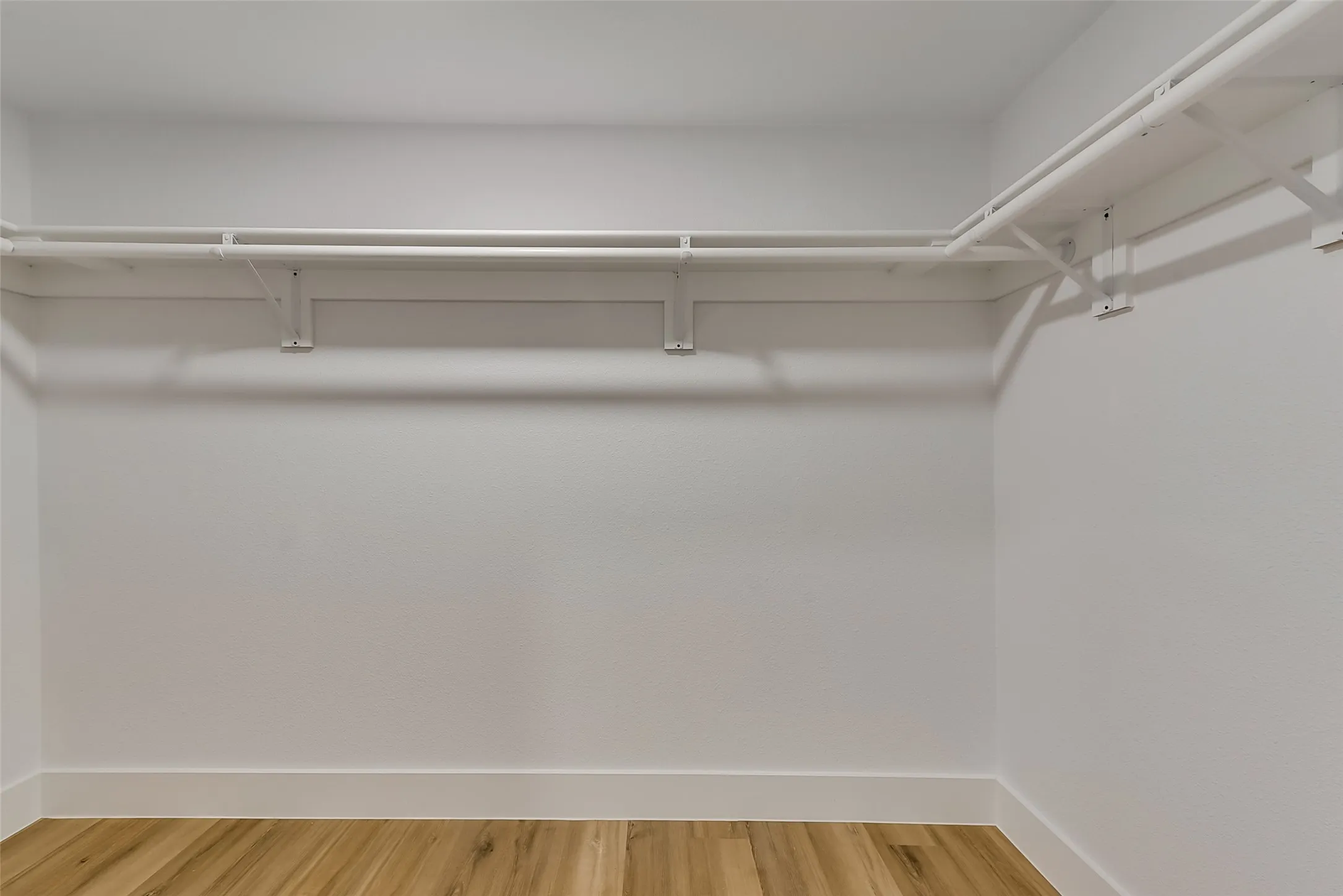 Walk in closet with light wood-style flooring