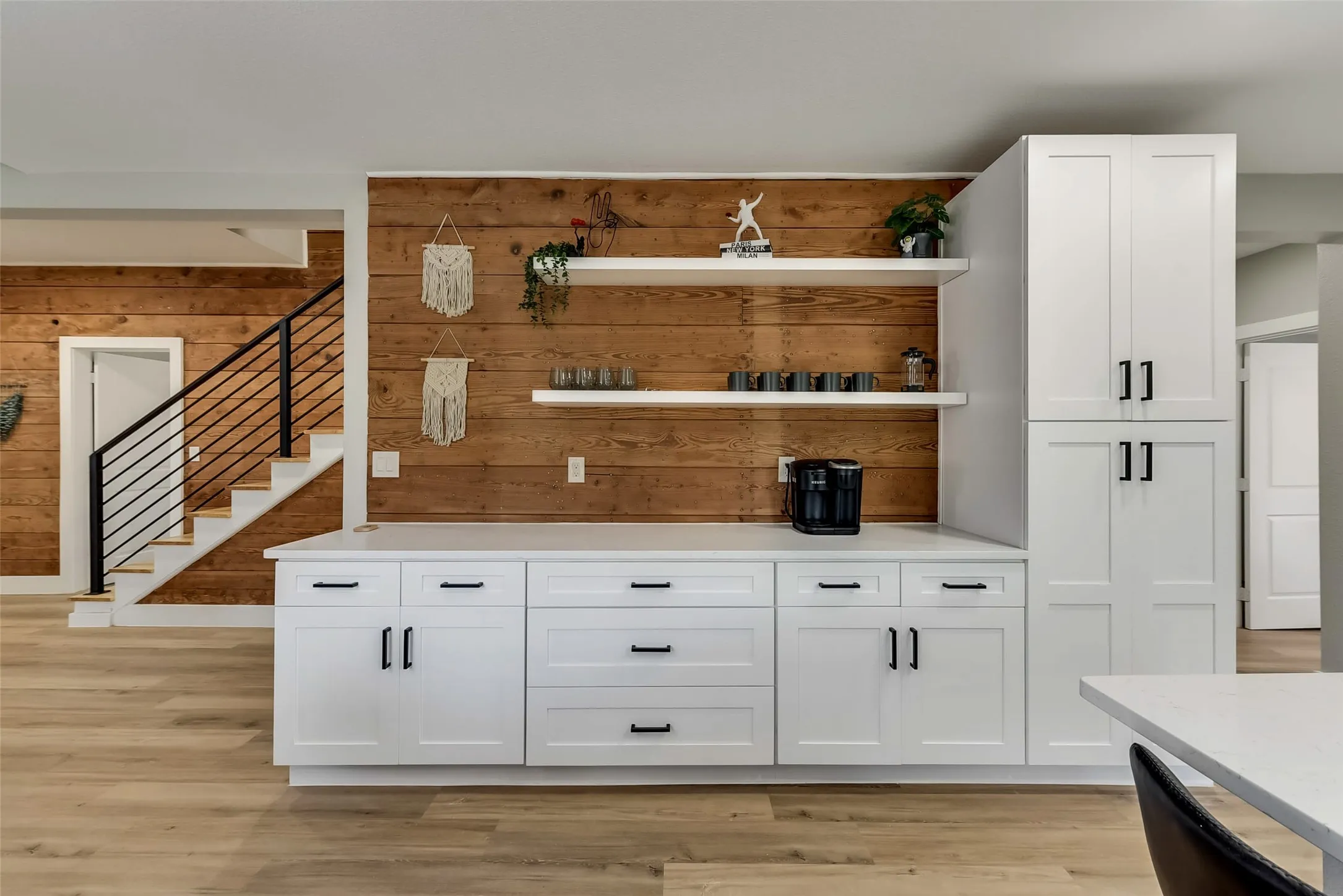 Bar featuring stairs, wooden walls, and light wood-style flooring