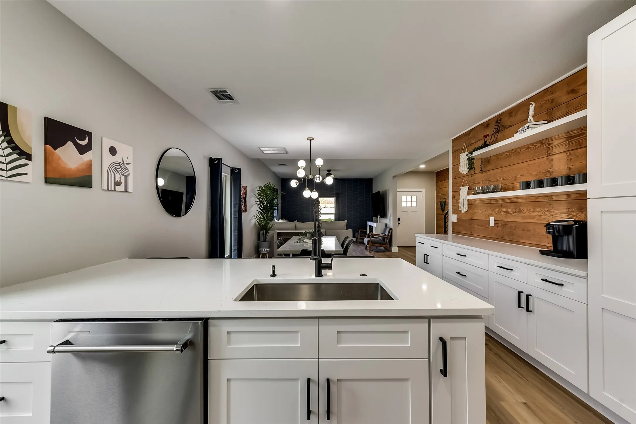 Kitchen with a notable chandelier, visible vents, a sink, open shelves, and light countertops