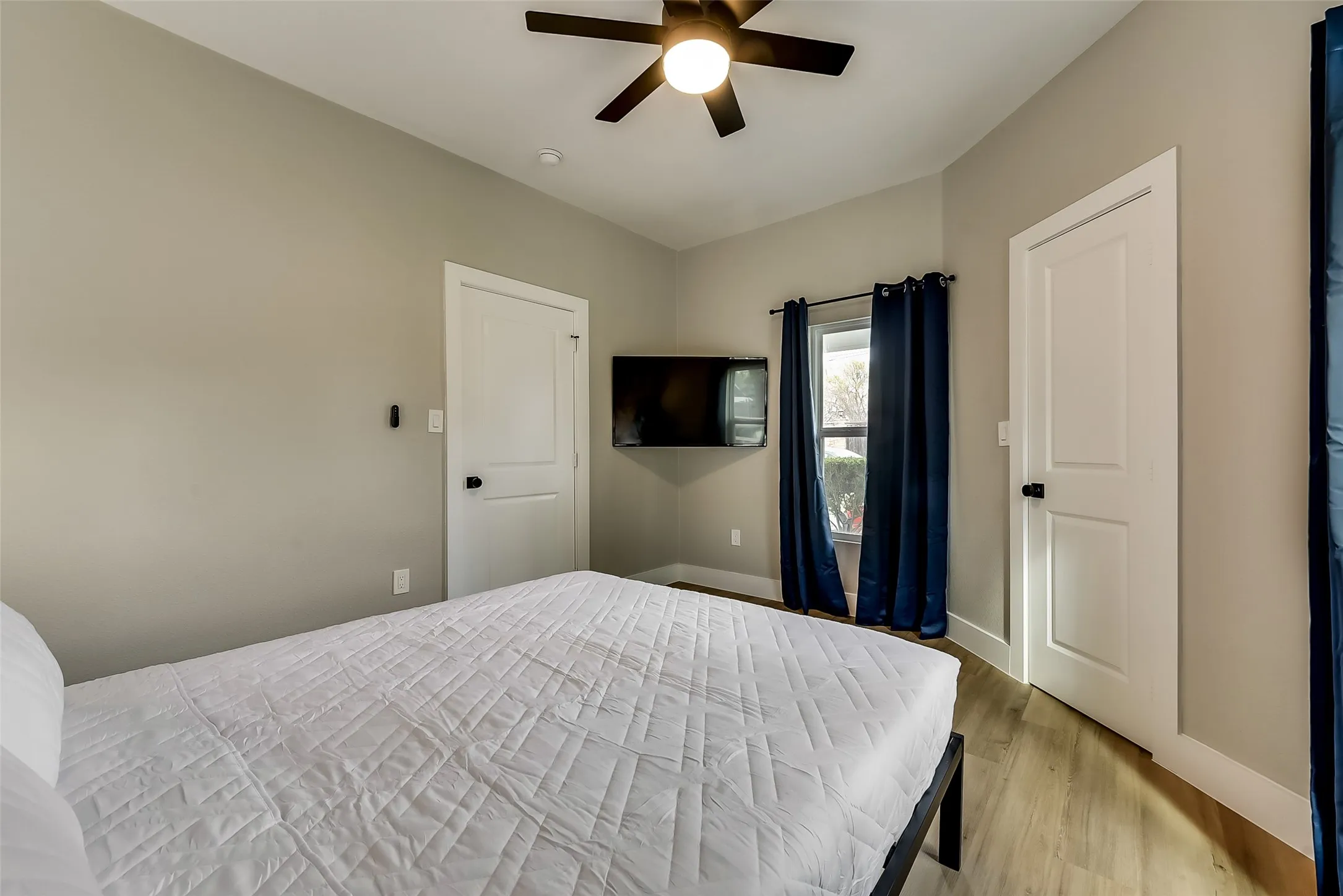 Bedroom featuring light wood finished floors, baseboards, and a ceiling fan