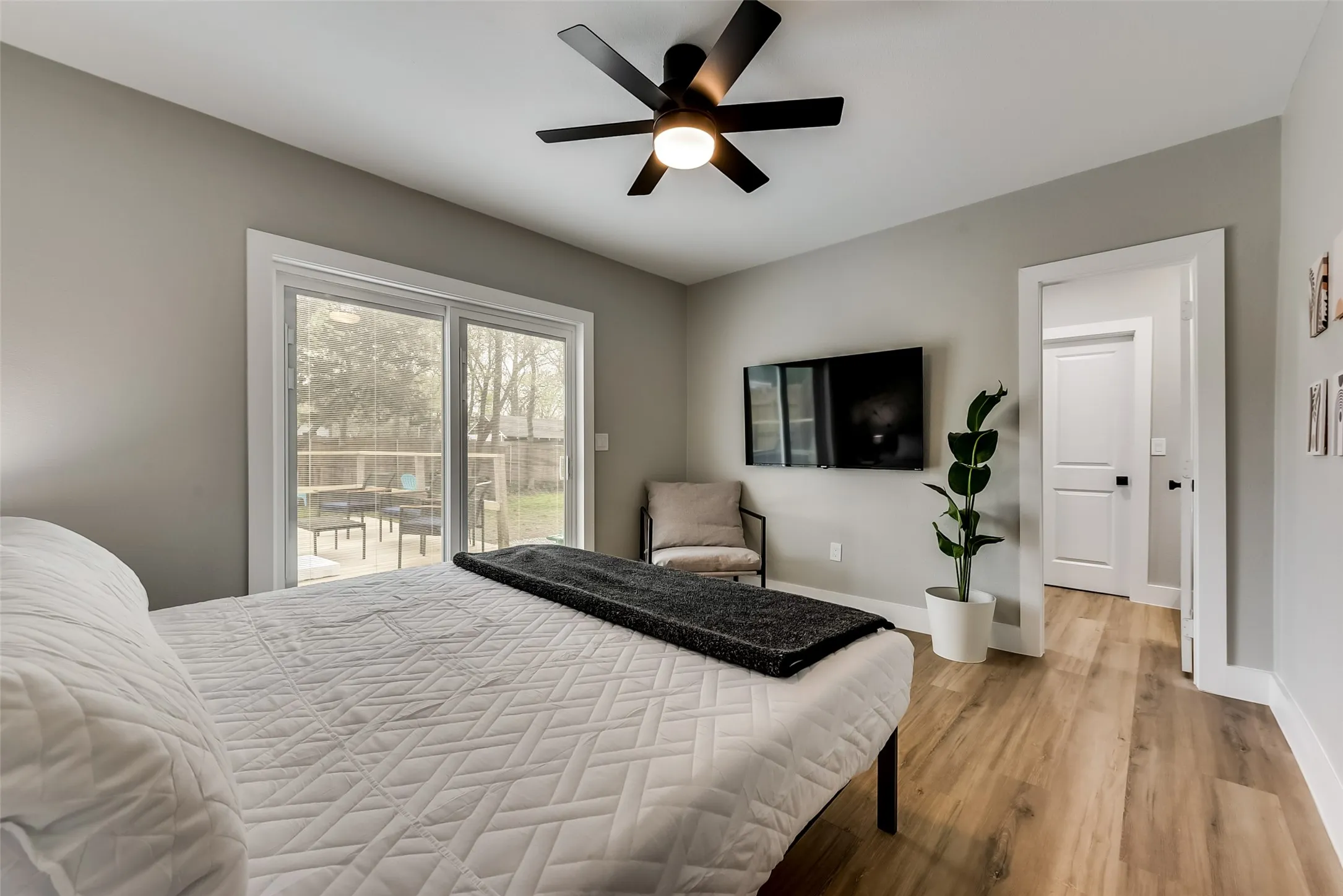Bedroom with light wood-type flooring, access to outside, baseboards, and ceiling fan