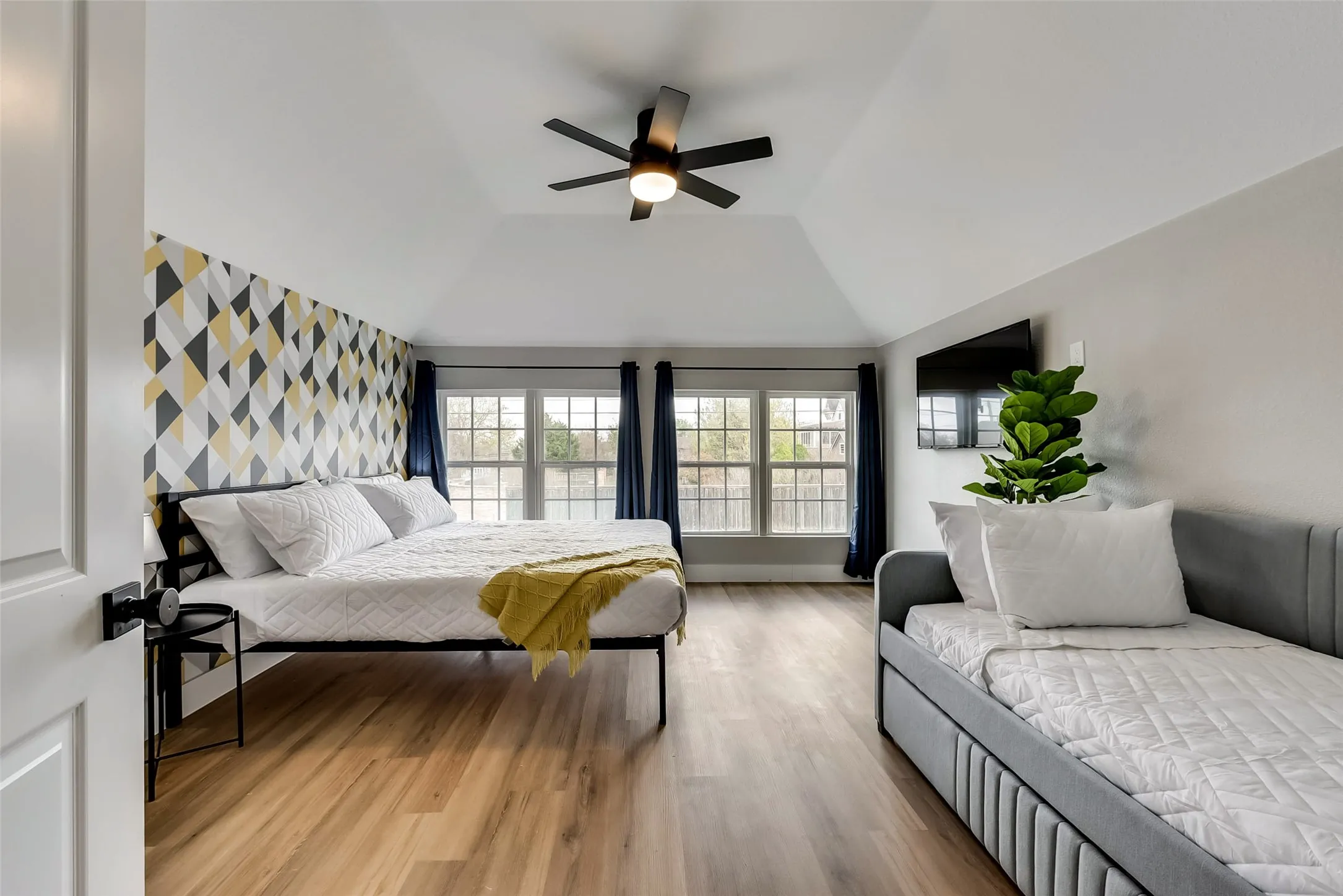 Bedroom featuring vaulted ceiling, wood finished floors, and ceiling fan