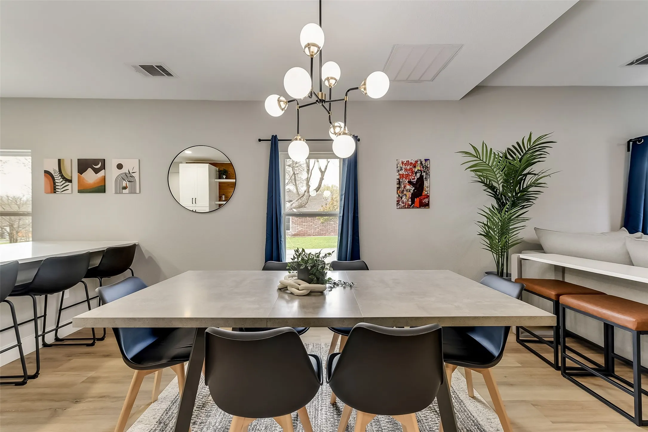 Dining area featuring an inviting chandelier, visible vents, and light wood-style floors