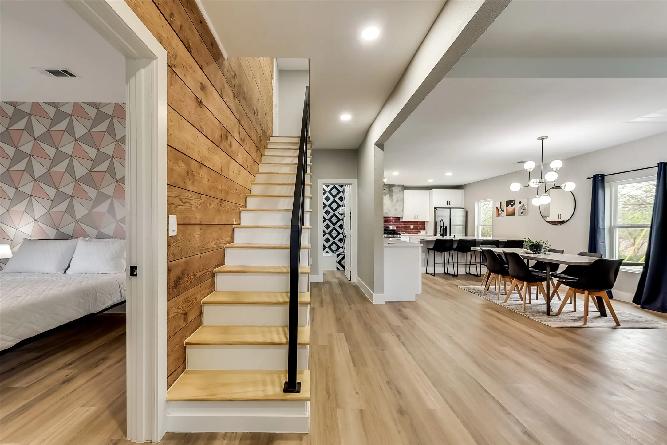 Staircase with a chandelier, recessed lighting, visible vents, and wood finished floors