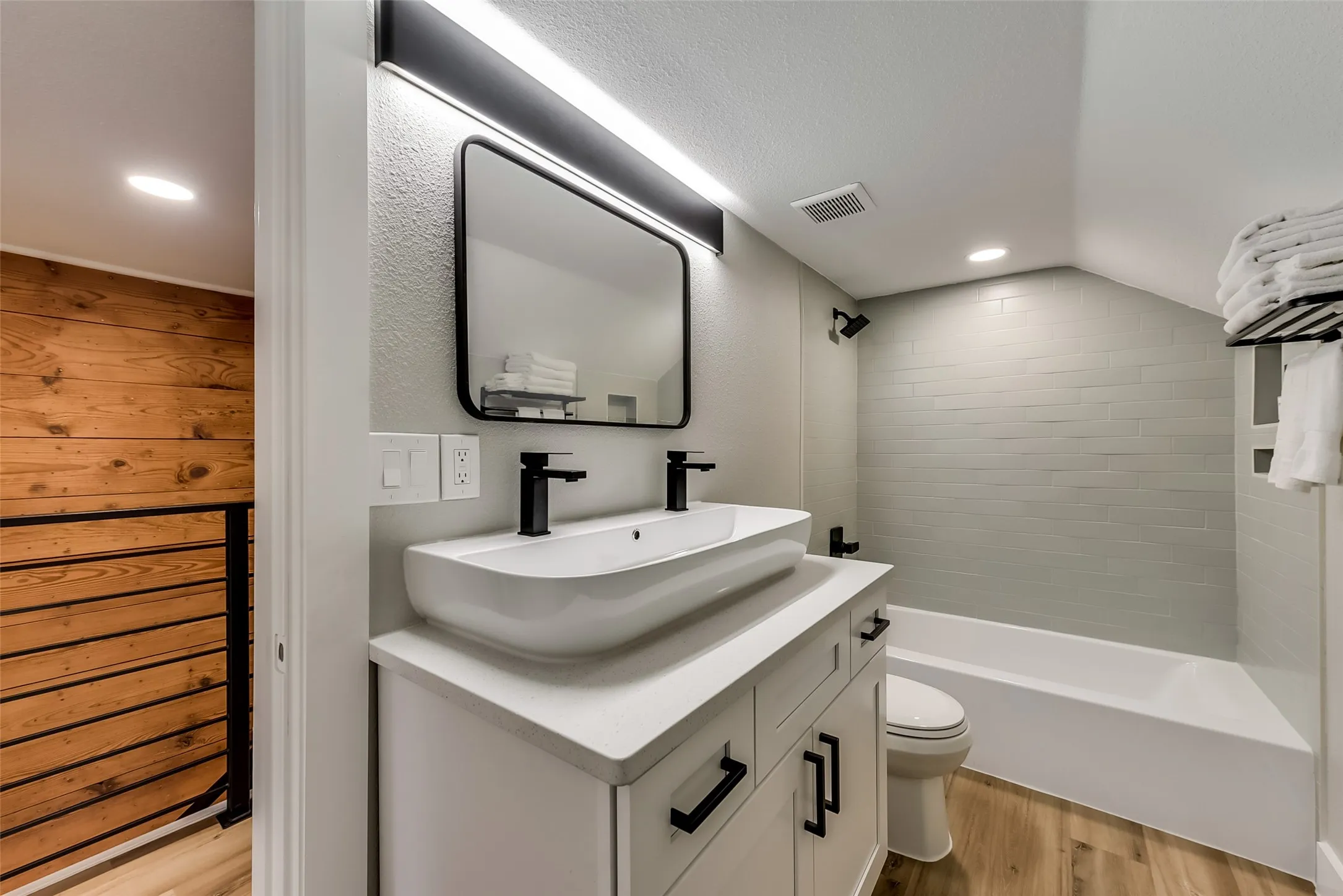Full bath featuring toilet,  shower combination, wood finished floors, visible vents, and vanity