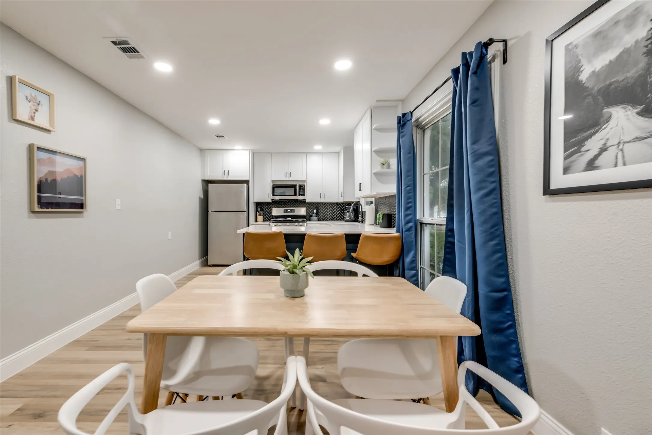 Dining area with recessed lighting and light wood finished floors