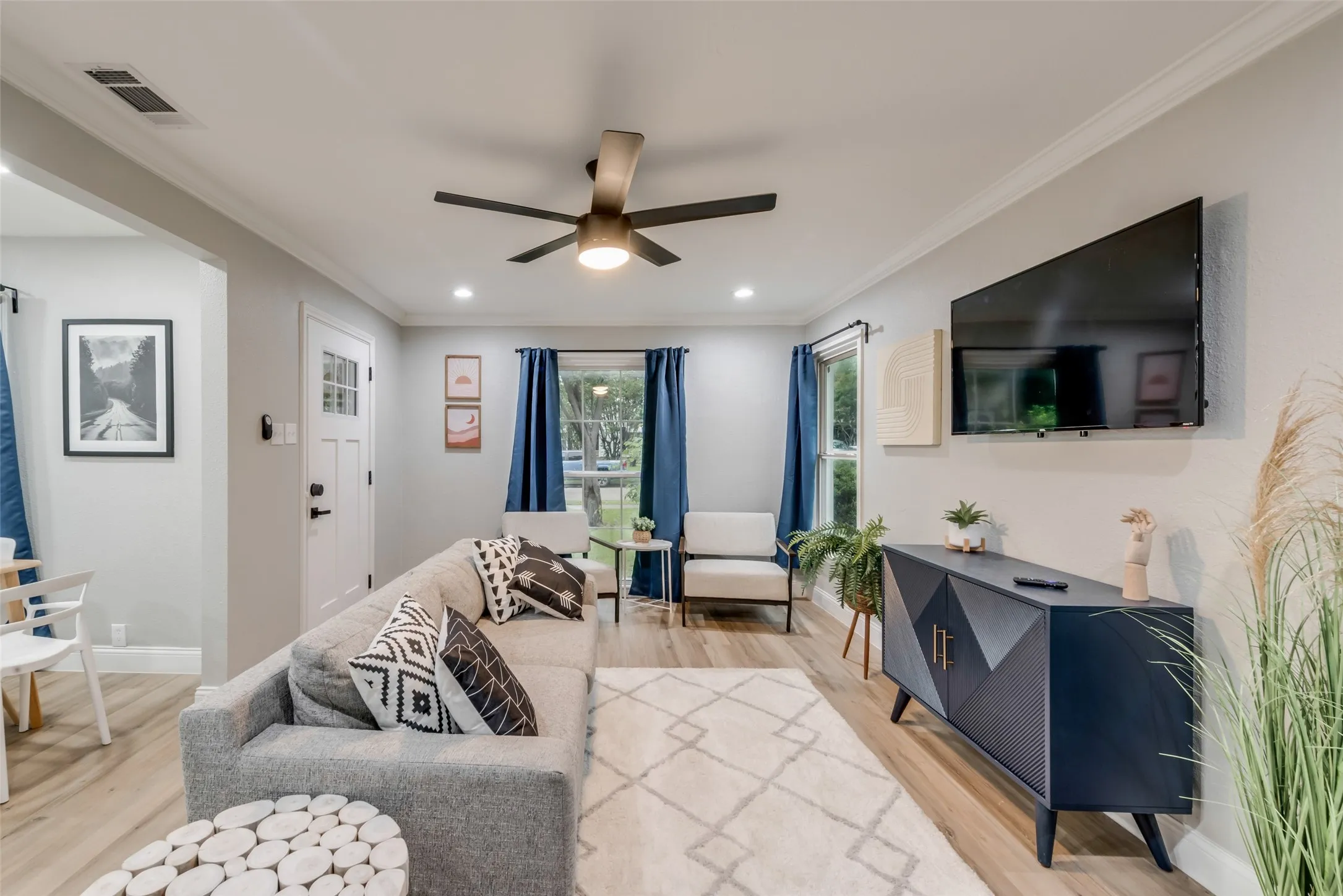 Living room featuring crown molding, light wood finished floors, a ceiling fan, and recessed lighting