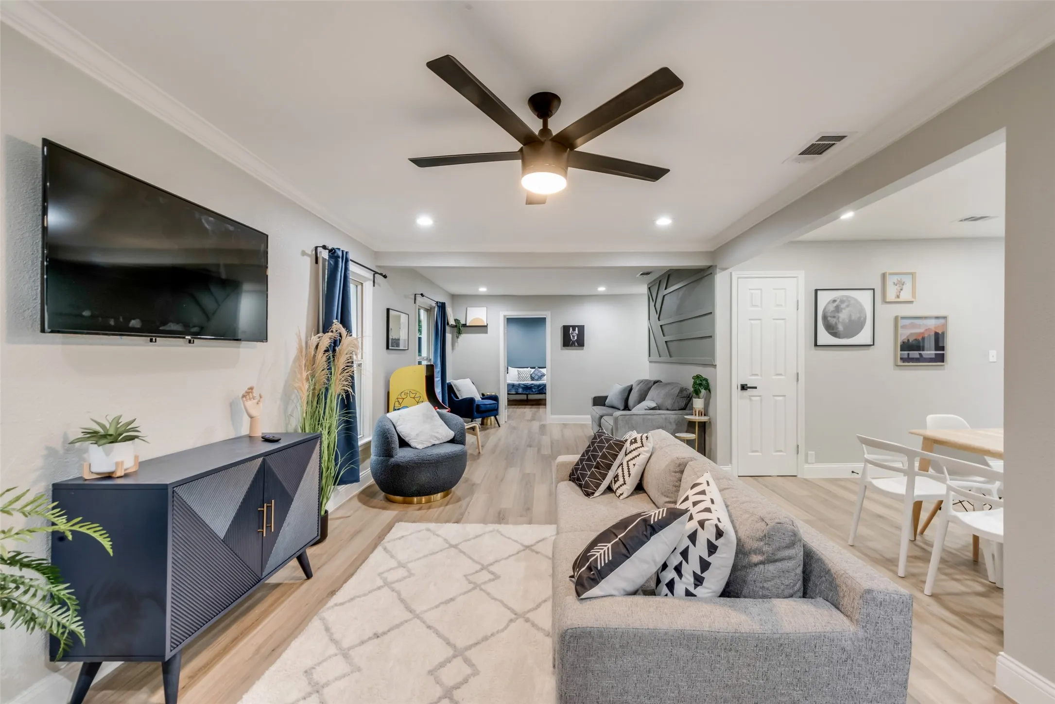 Living area with ceiling fan, light wood finished floors, crown molding, and recessed lighting