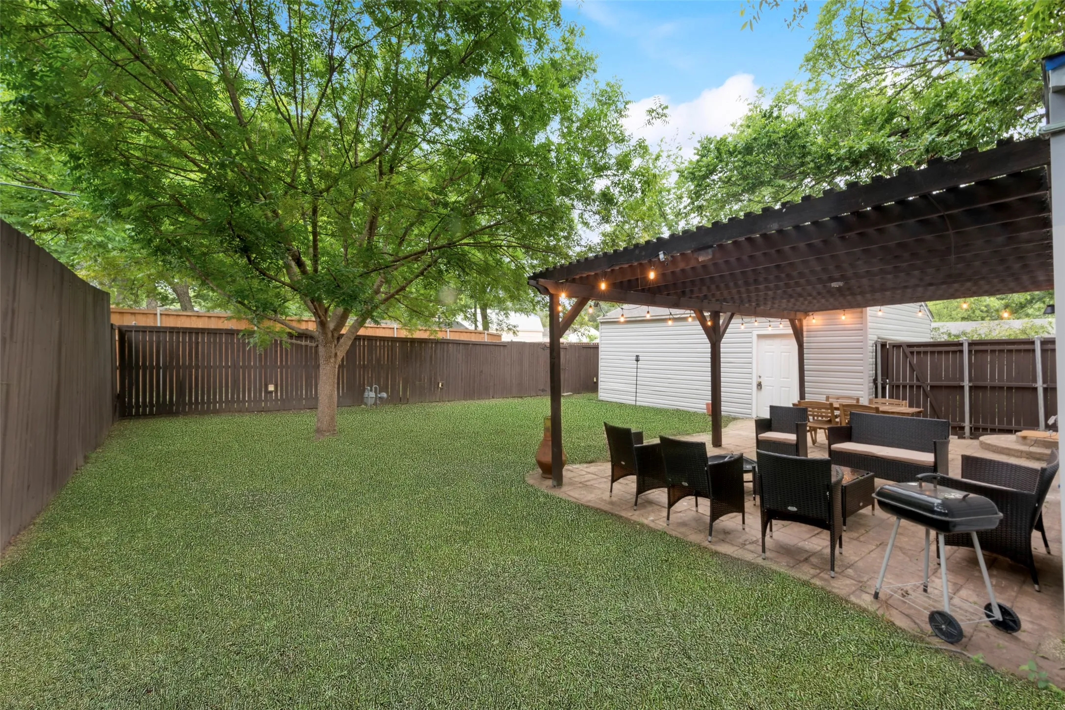 Fenced backyard with outdoor lounge area, a pergola, and a patio